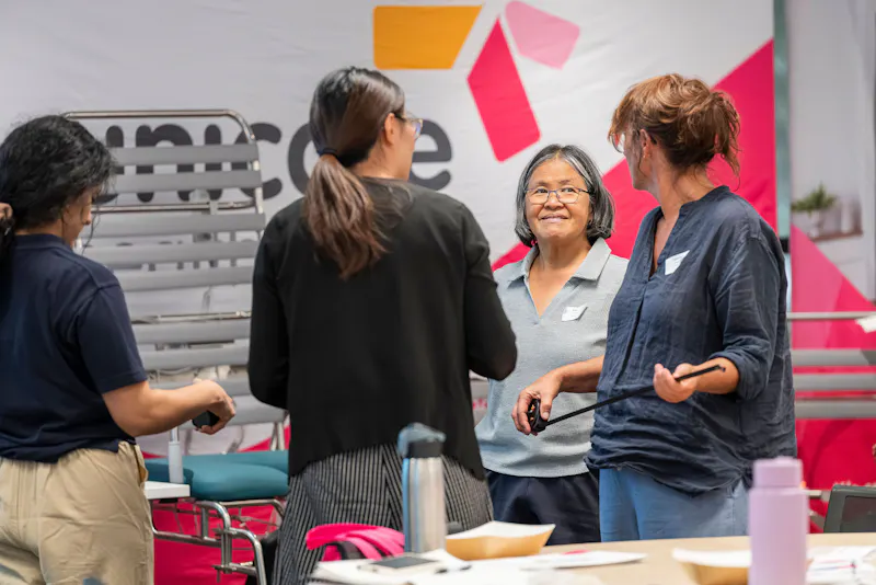 Occupational Therapists discussing shower commode features and clinical applications during Unicare Health bathroom mobility training workshop in Perth WA