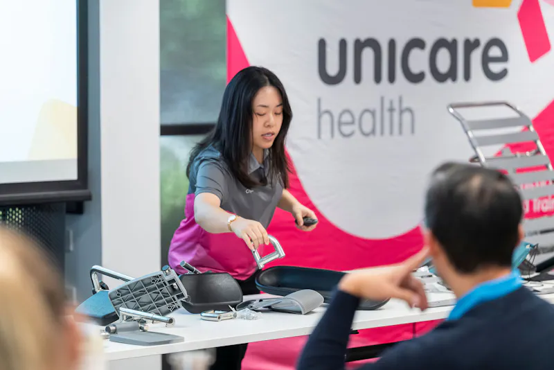 Crystal Chan presenting shower commode accessories and components during Unicare Health bathroom mobility CPD training in Perth WA
