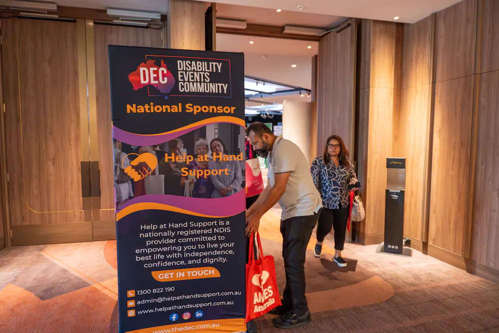 Attendees arriving at Bankstown Disability Expo NSW at Canterbury League Club Belmore, with Disability Events Community signage welcoming visitors to the event