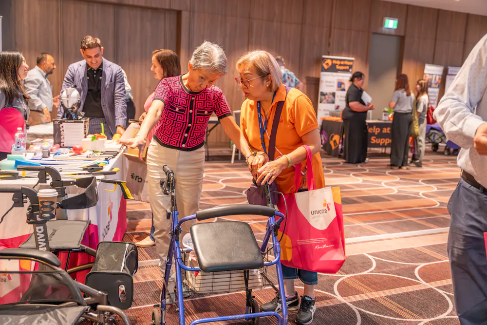 Attendees exploring mobility aids and assistive equipment at Unicare stand during Bankstown Disability Expo NSW at Canterbury League Club Belmore