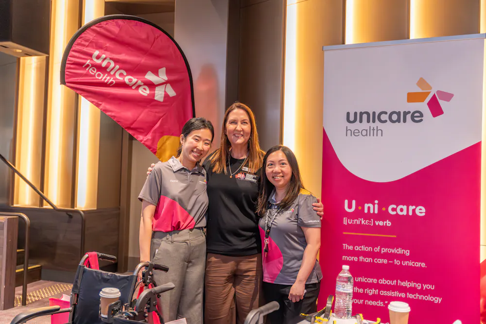 Unicare team members at Bankstown Disability Expo NSW standing at exhibition booth with assistive equipment at Canterbury League Club Belmore