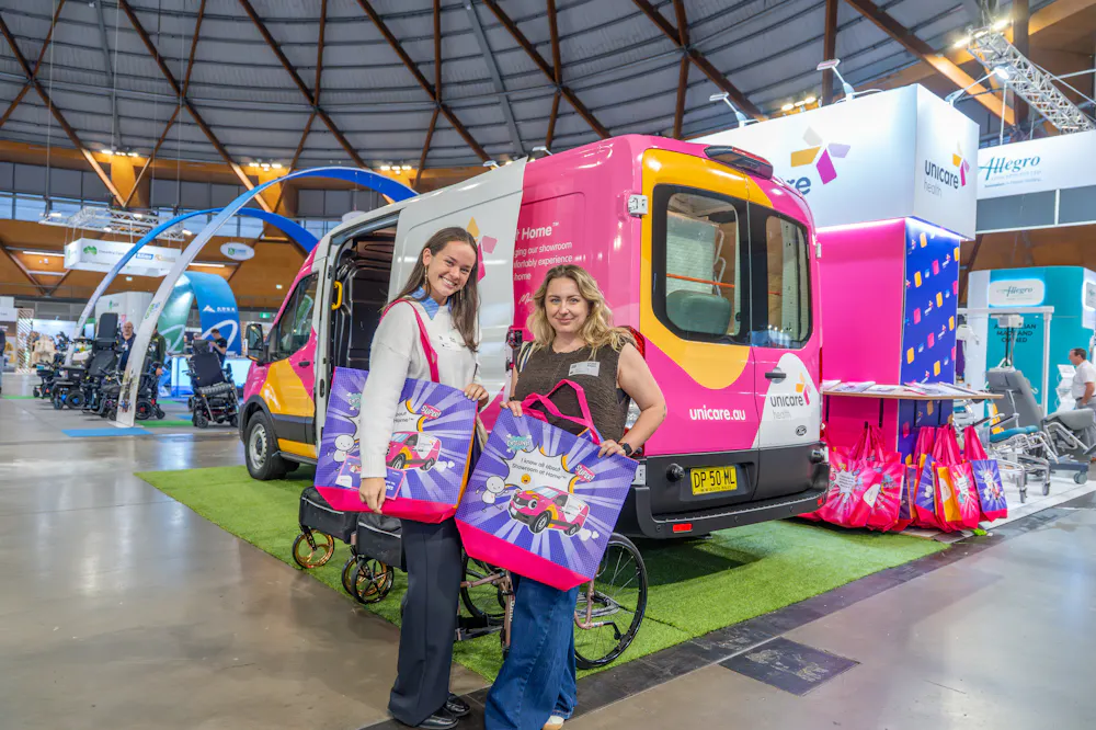 Attendees with Unicare Health showbags beside the Showroom at Home™ van at the ATSA Independent Living Expo Sydney 2026.