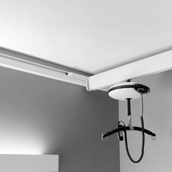Ceiling hoist suspended from a wall-mounted track.