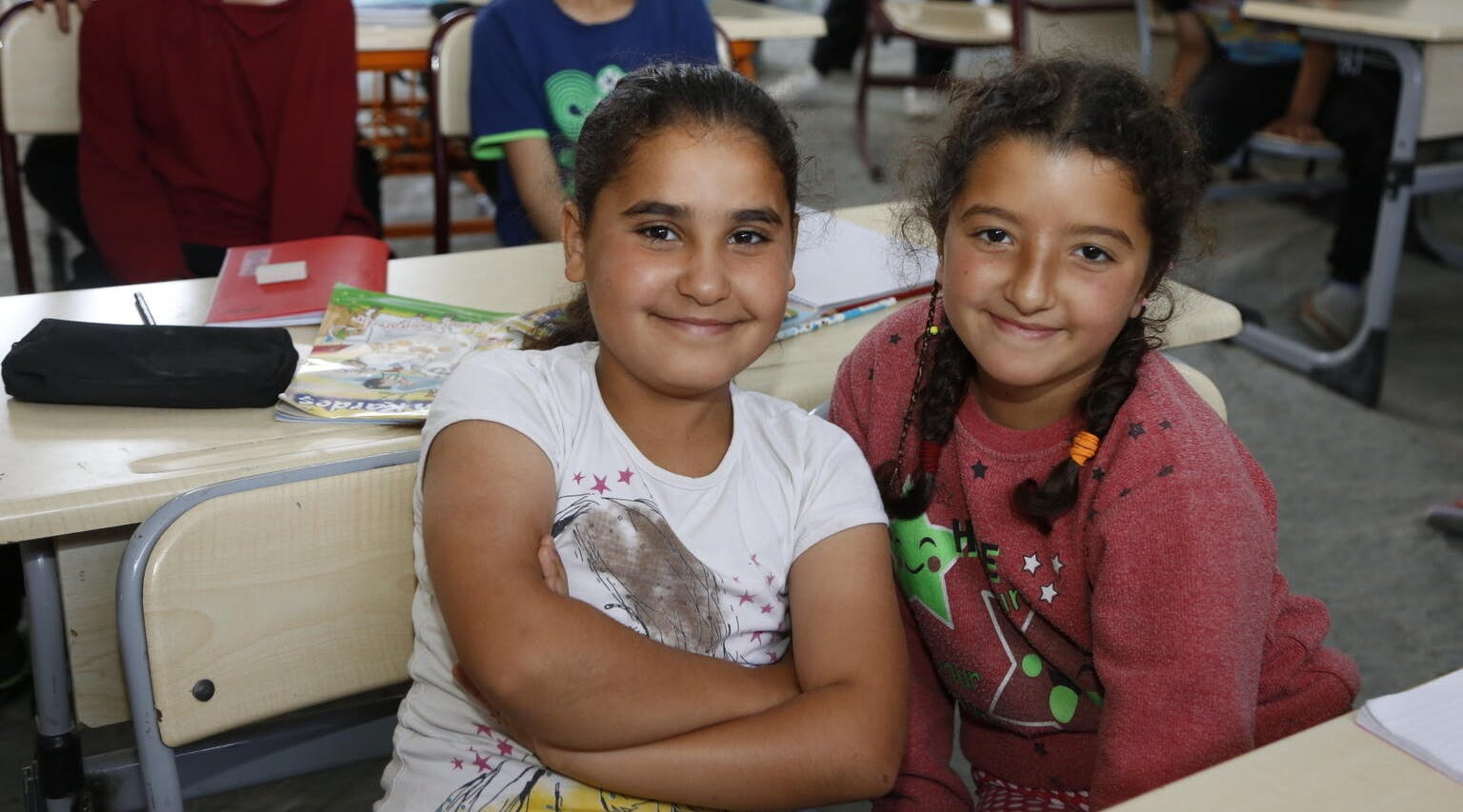 Türkiye-Syria Earthquake Emergency, Two friends attend a class held at a UNICEF-supported tent classroom in Hatay, Türkiye.
