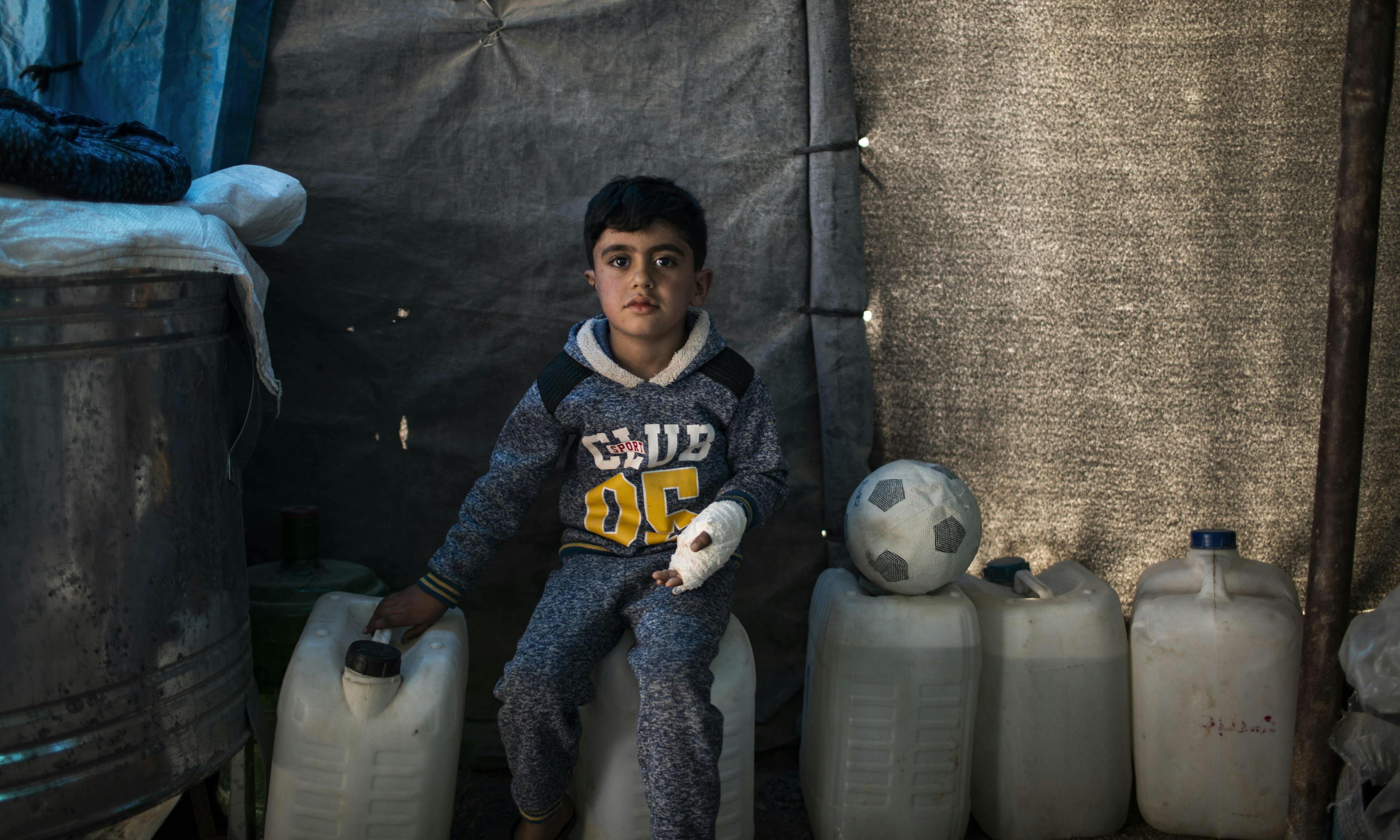 Hidden explosives | 5-year-old Hussein sits on a water container at his temporary home in Habaniya, on the outskirts of Fallujah.