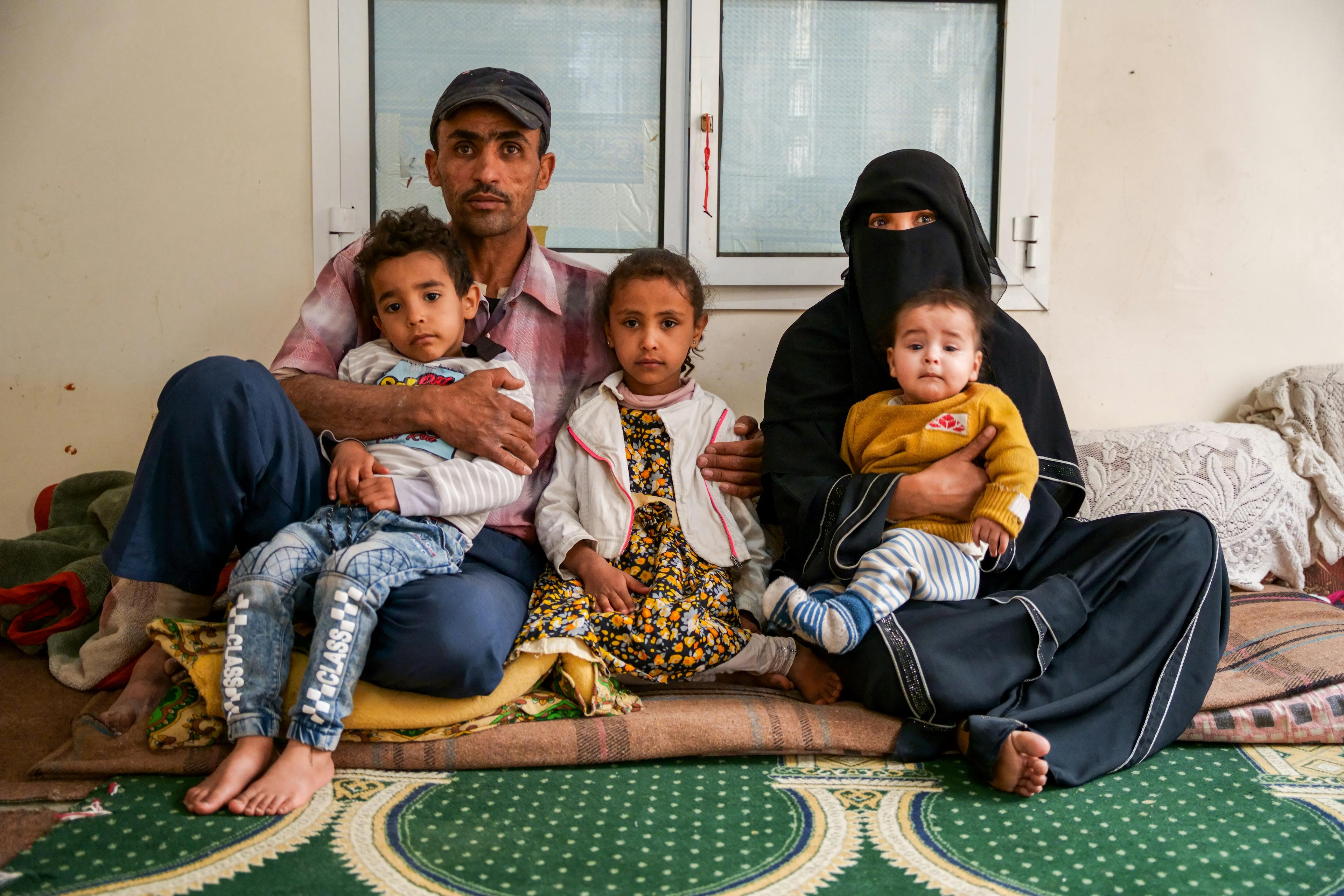 Nabil sits with his wife Salma and their children Mayar, Mohammed, and Ahmed in their apartment located in Dhamar Governorate, Yemen.