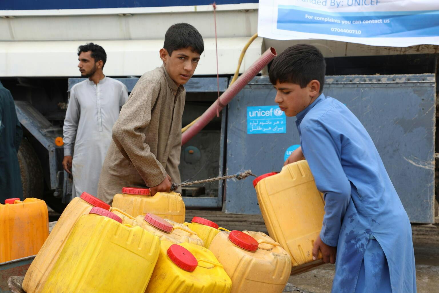 Children collect water from a UNICEF-supported water truck in Logar Province, Afghanistan.