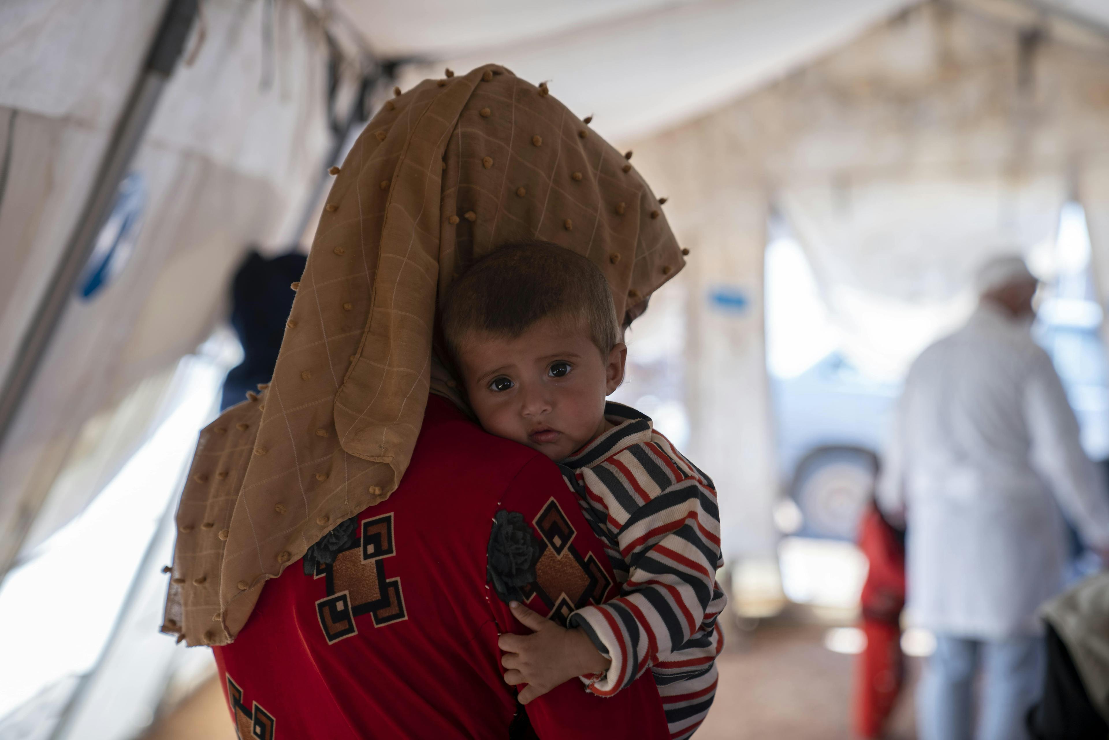 Nine month old baby Doumou hugging onto her mother Outor, as she is taken for a check-up at a UNICEF-mobile health clinic.