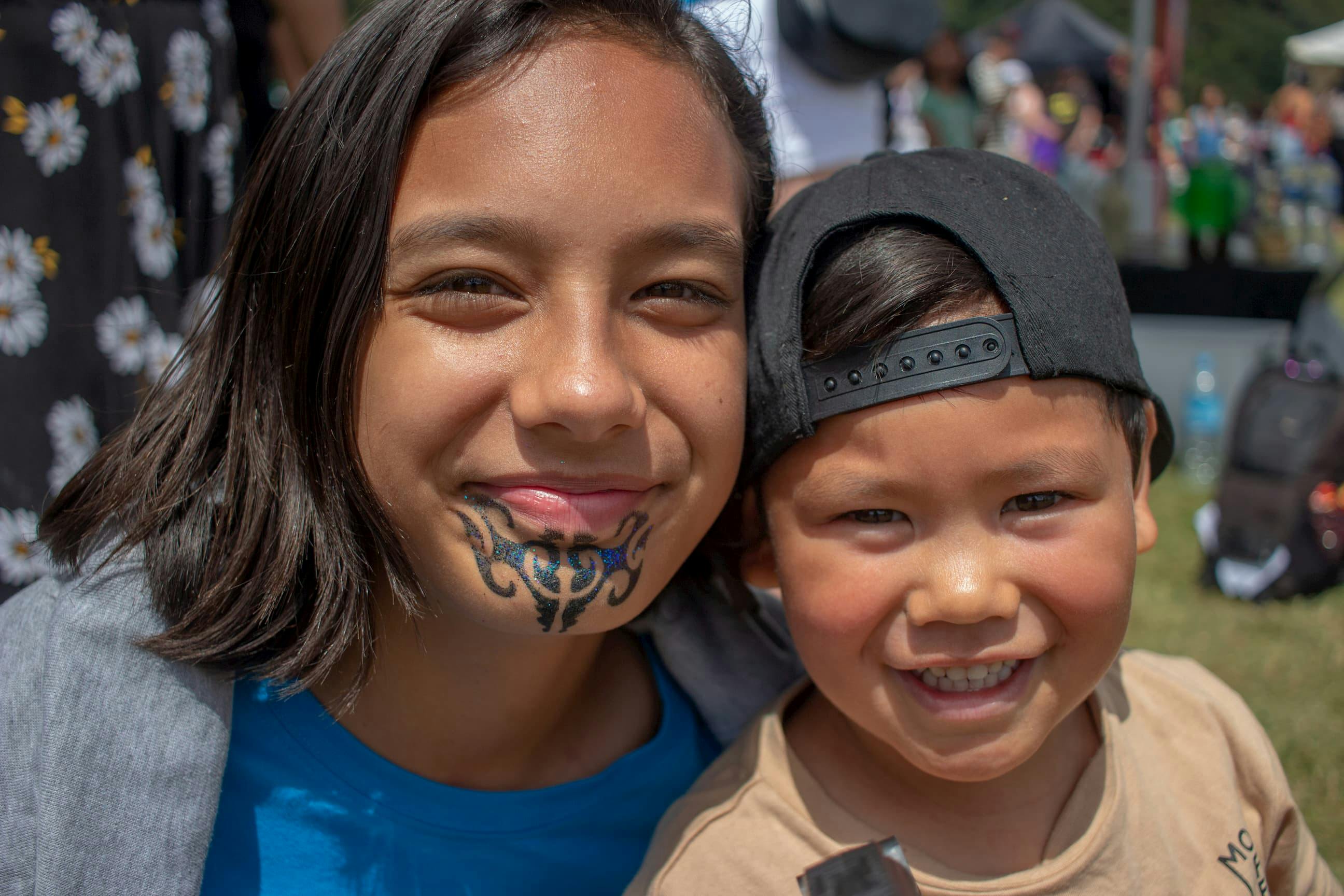 Two Māori tamariki smiling at the camera during UNICEF children's day