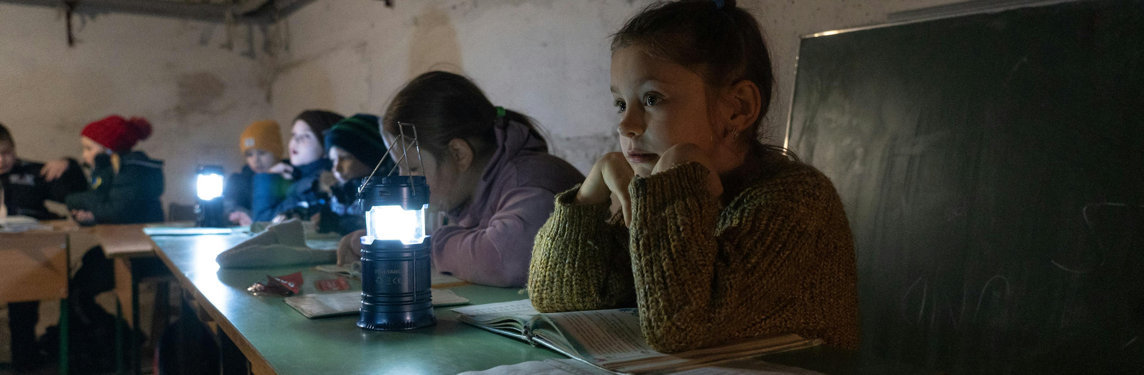 10-year-old Margaryta with other children are sitting at the shelter of the kindergarten, where UNICEF has delivered new generators.