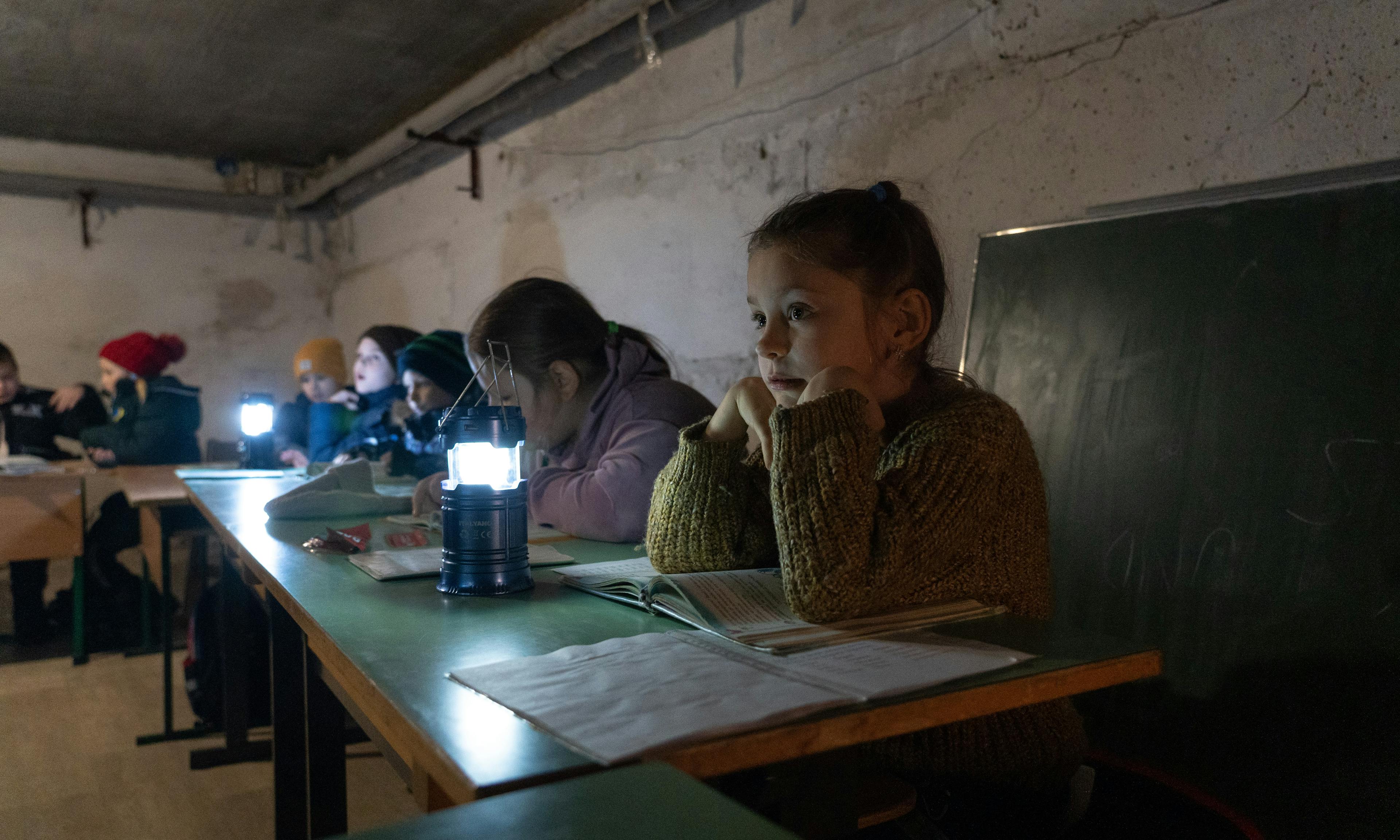 10-year-old Margaryta with other children are sitting at the shelter of the kindergarten, where UNICEF has delivered new generators.