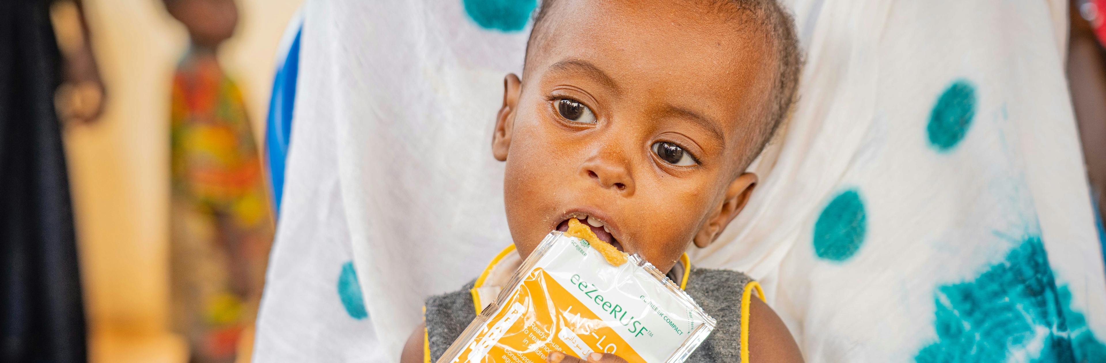 Abdrahamane (1 year old) a displaced child eats peanuts at the mobile clinic offering multiple services (vaccination, detection and follow-up of malnutrition cases, prenatal consultation, detection and follow-up of malaria cases, etc.) on the BAWA site intended to displaced persons.