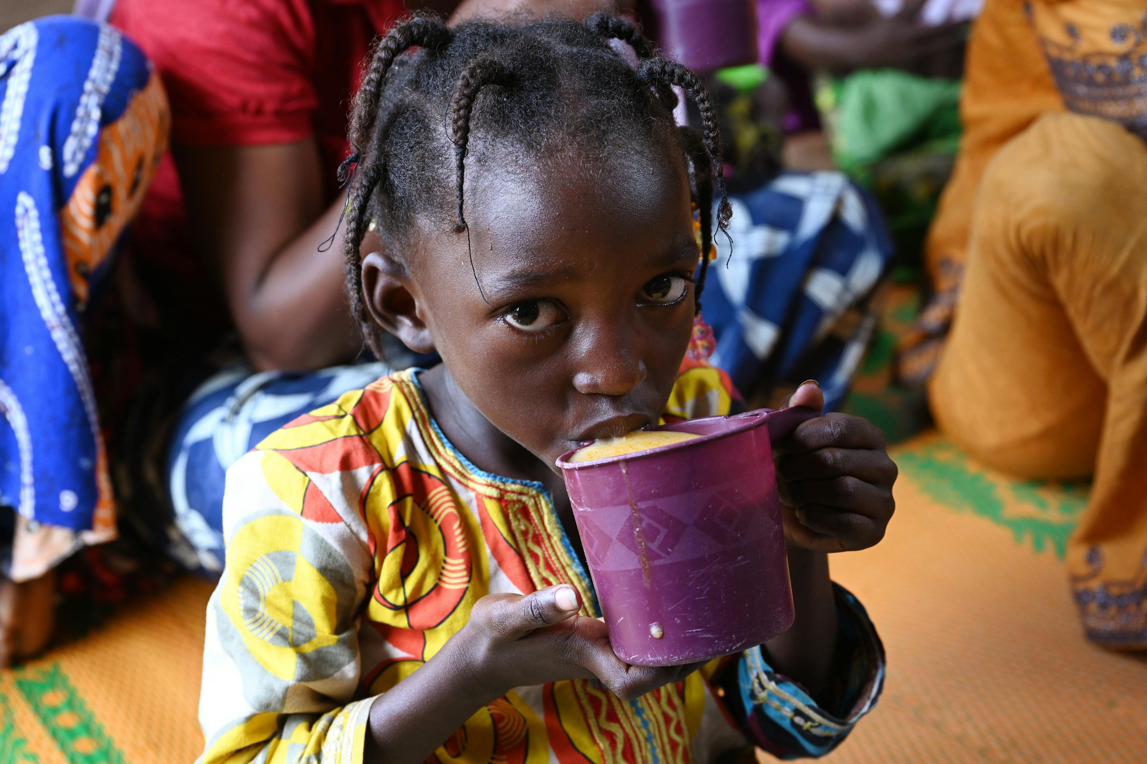 A little girl drinks a nutritious soup