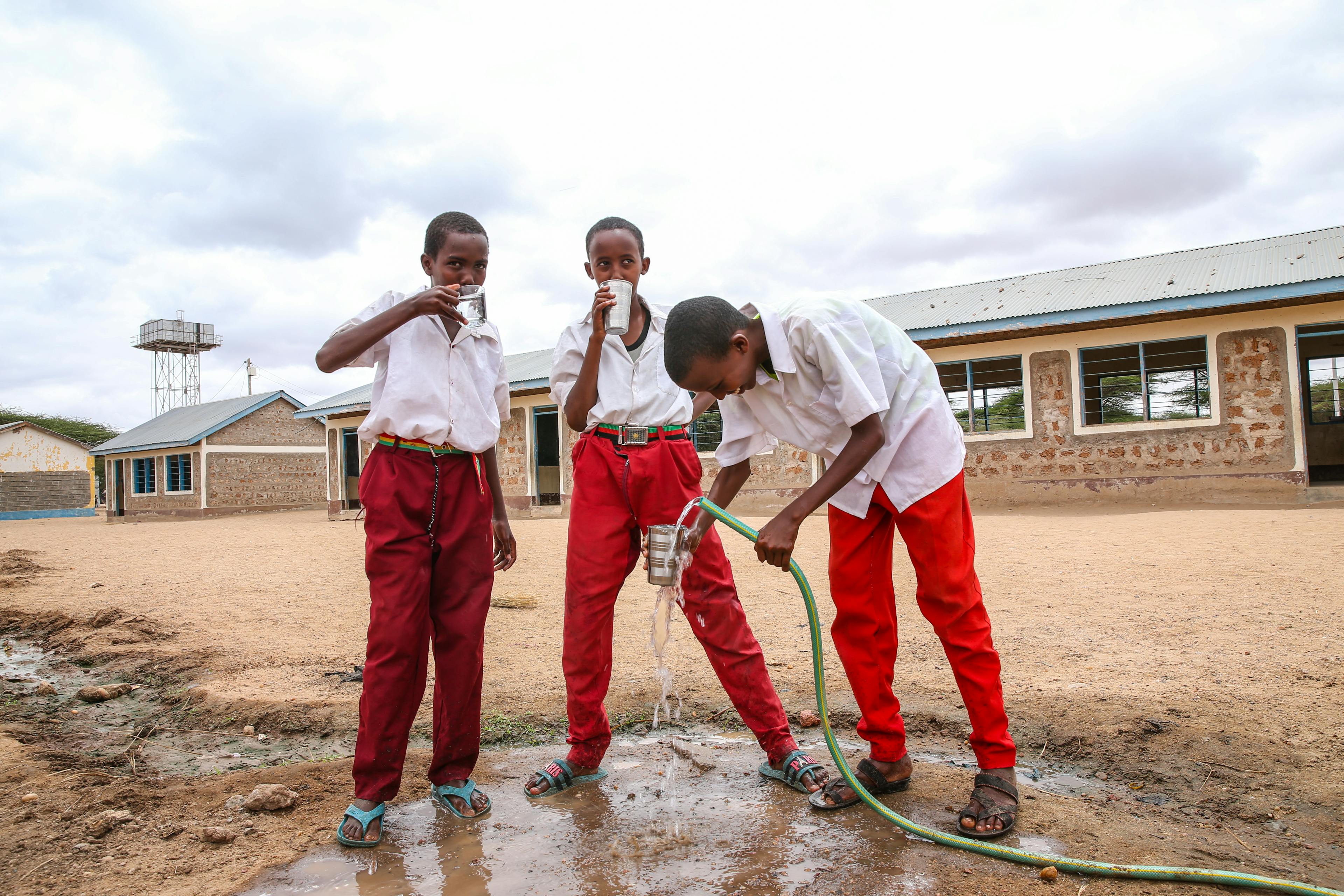  A group of boys drinking clean water from a tap