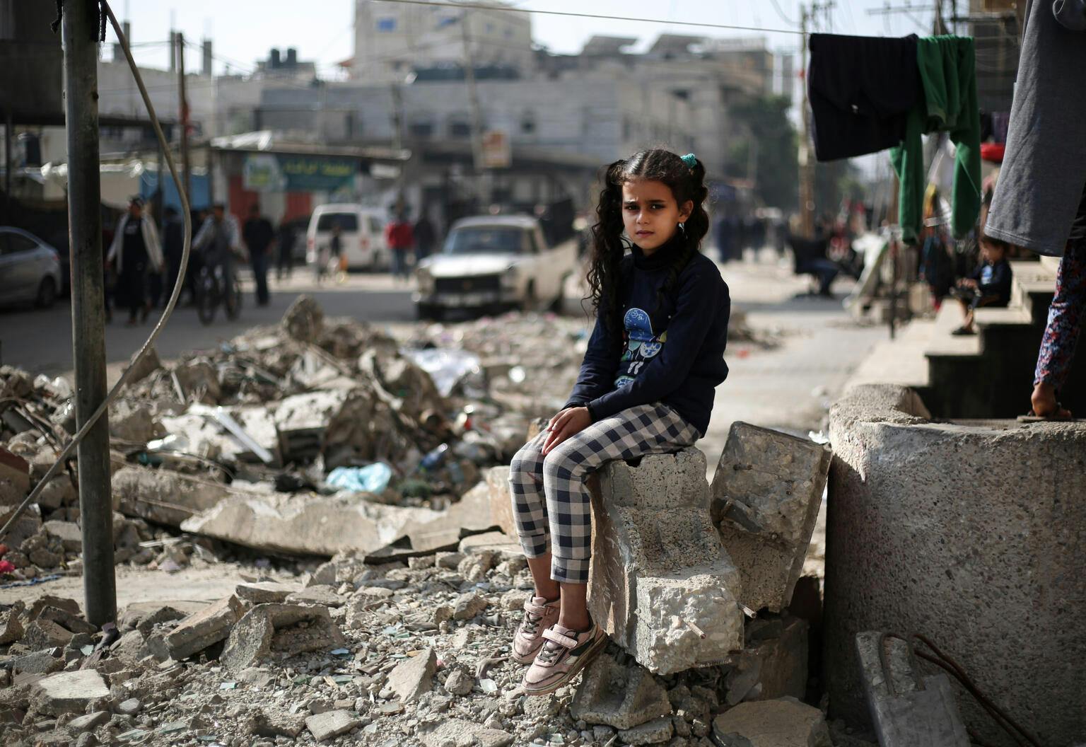 11 year-ol Maha sitting on the rubble of a house in Rafah, southern the Gaza Strip.