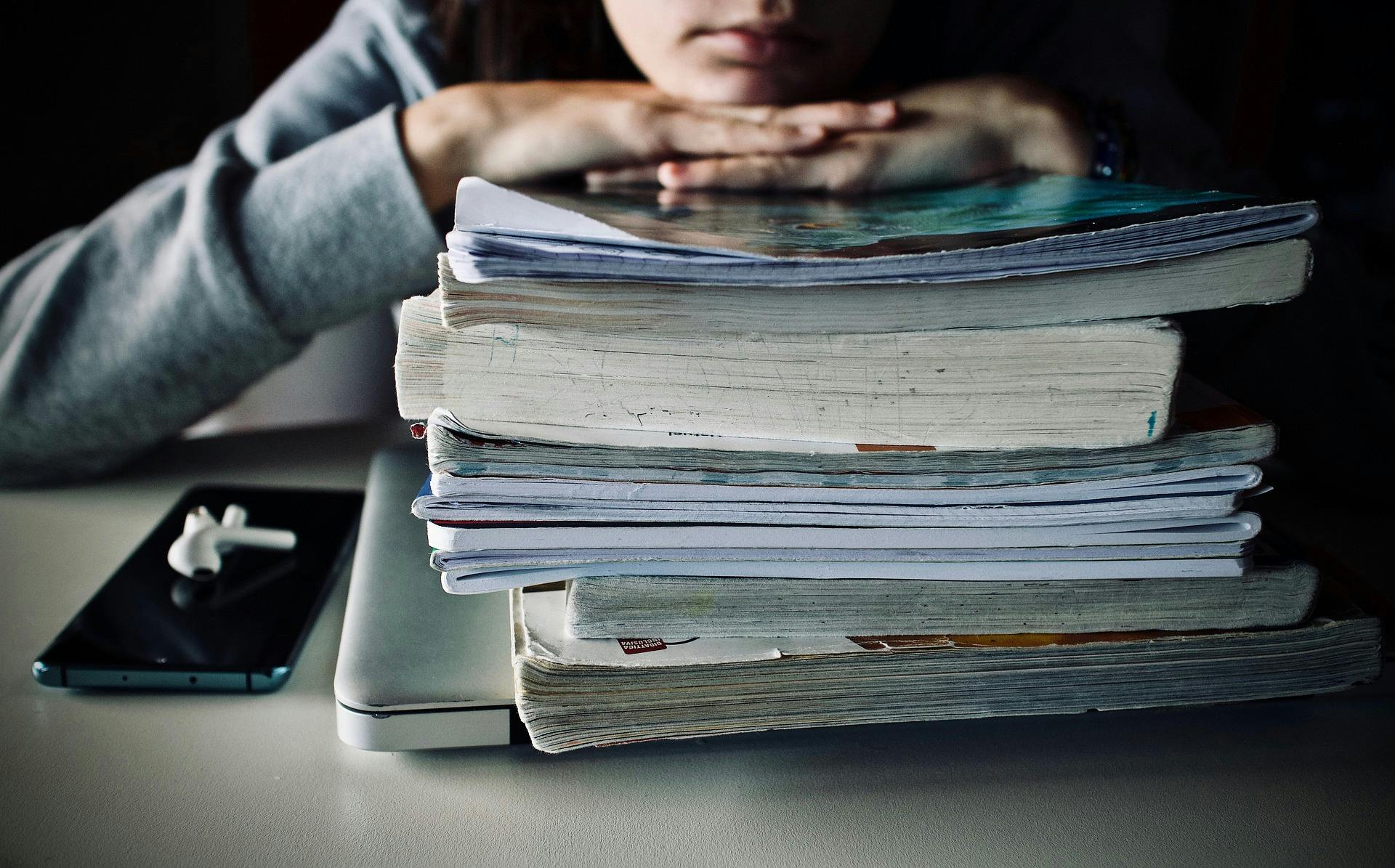 A child with a stack of books