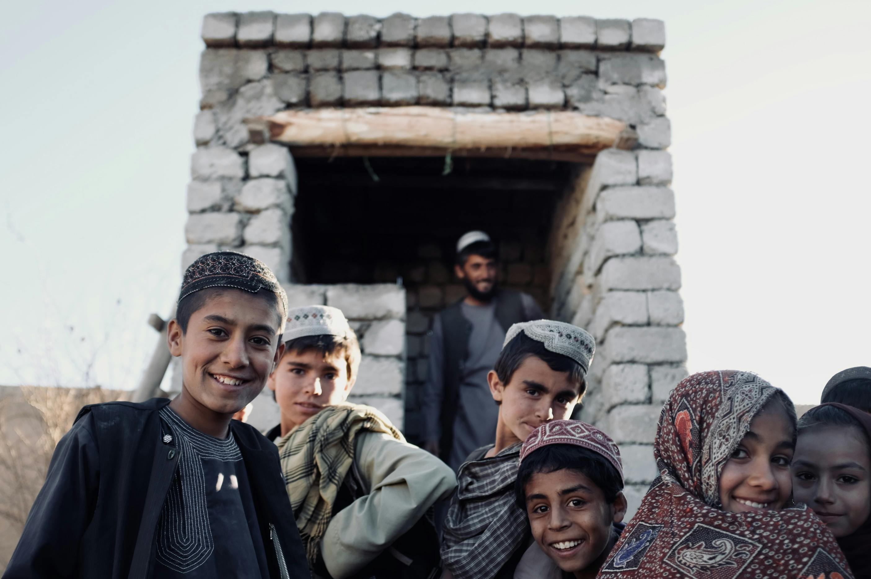 Children in front of a toilet under construction in Sola Village, Tarinkot District.