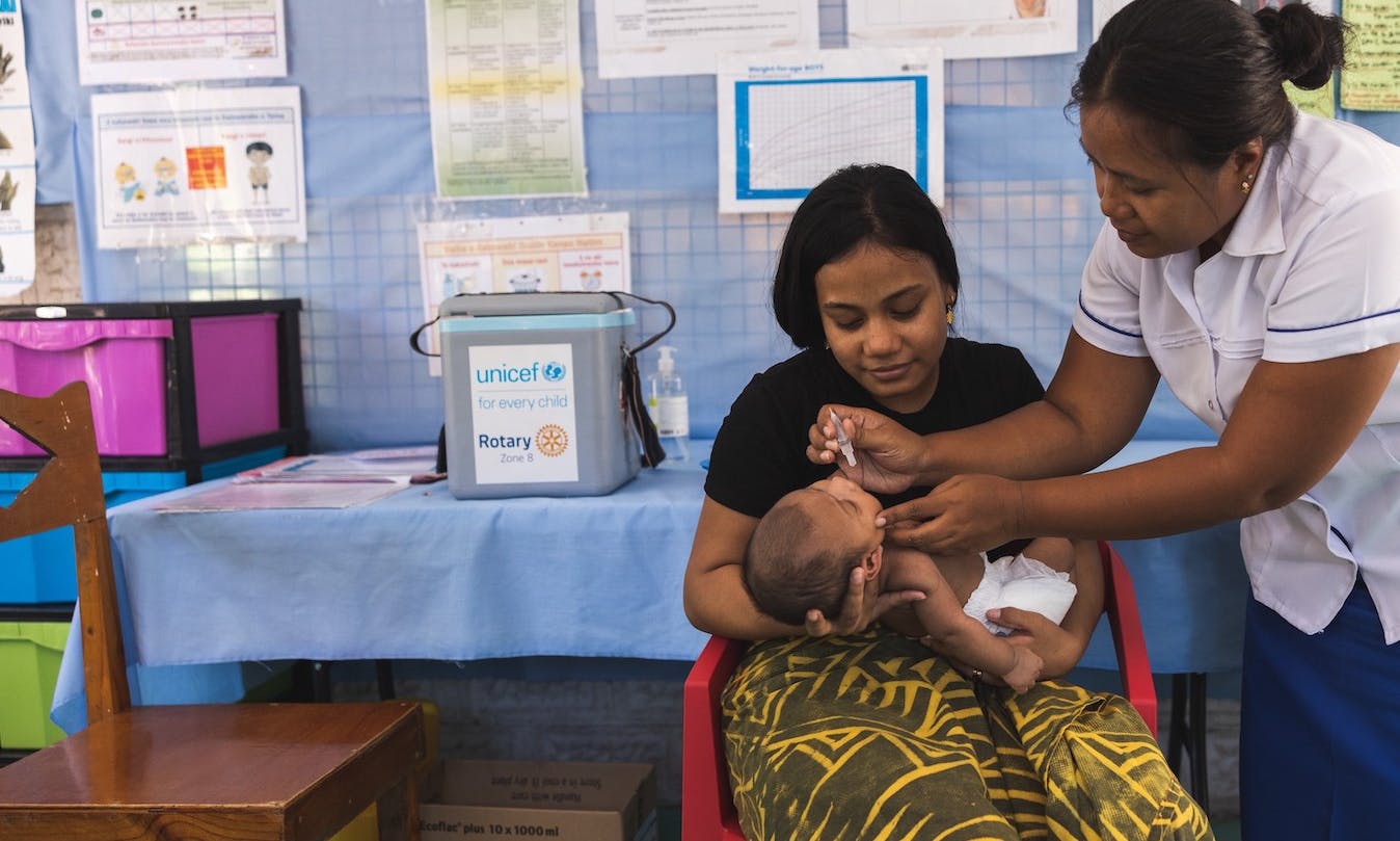 A child in the Pacific receives a dose of life-saving vaccine.