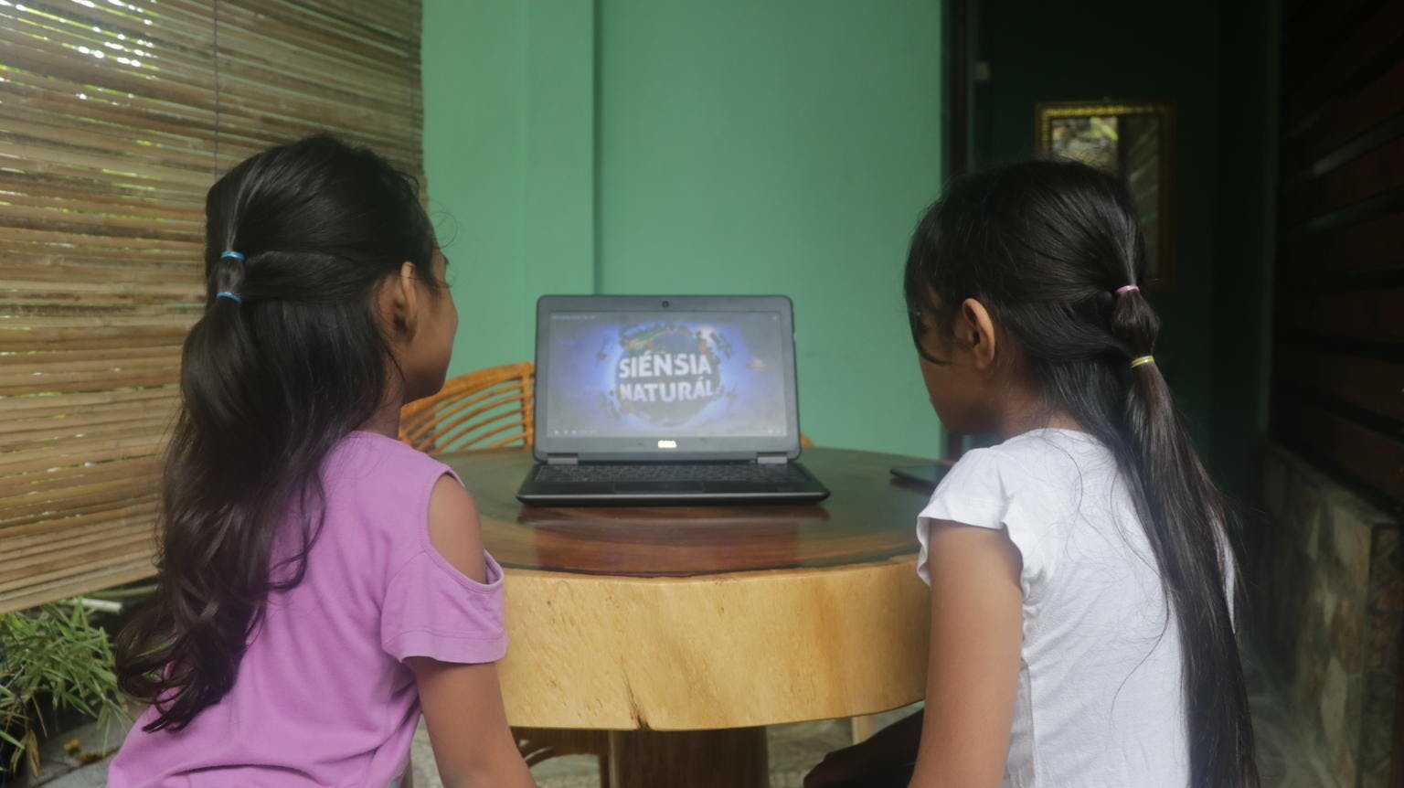 Two girls view the learning platform where they can view a mix of digital learning resources including audio and Visal material.