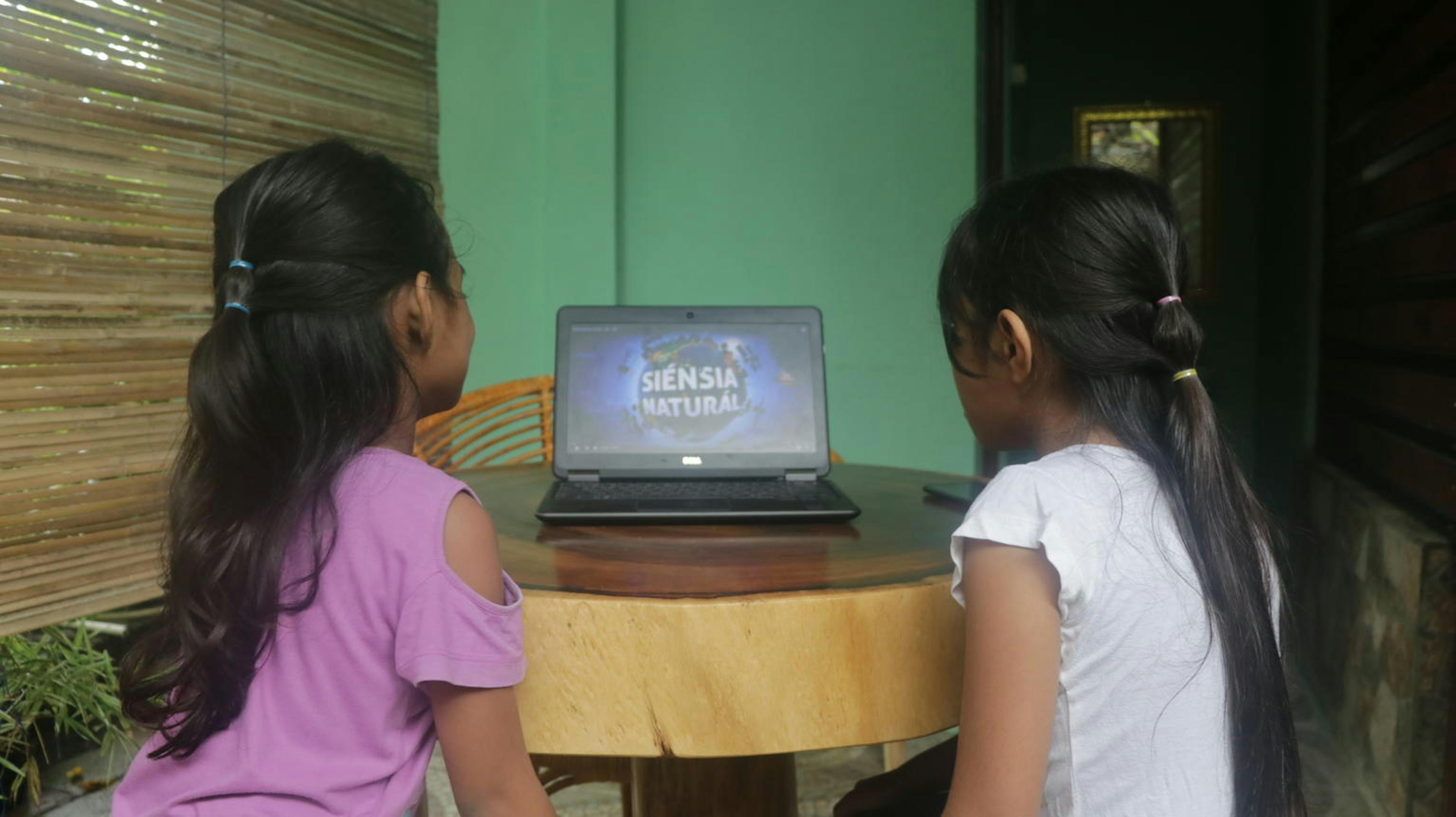 Two girls view the learning platform where they can view a mix of digital learning resources including audio and Visal material.