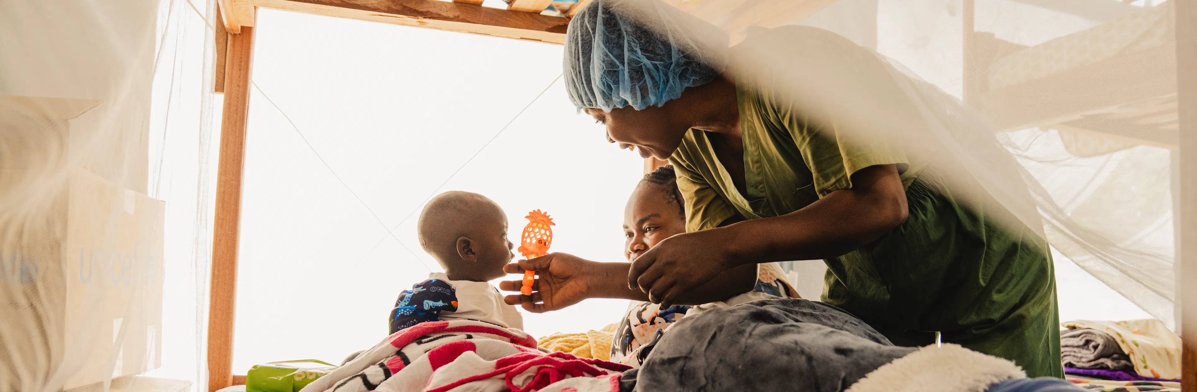 Wivine is with a child at the nursery for children whose parents are hospitalized at the Ebola Treatment Center in Bunia, Ituri province.