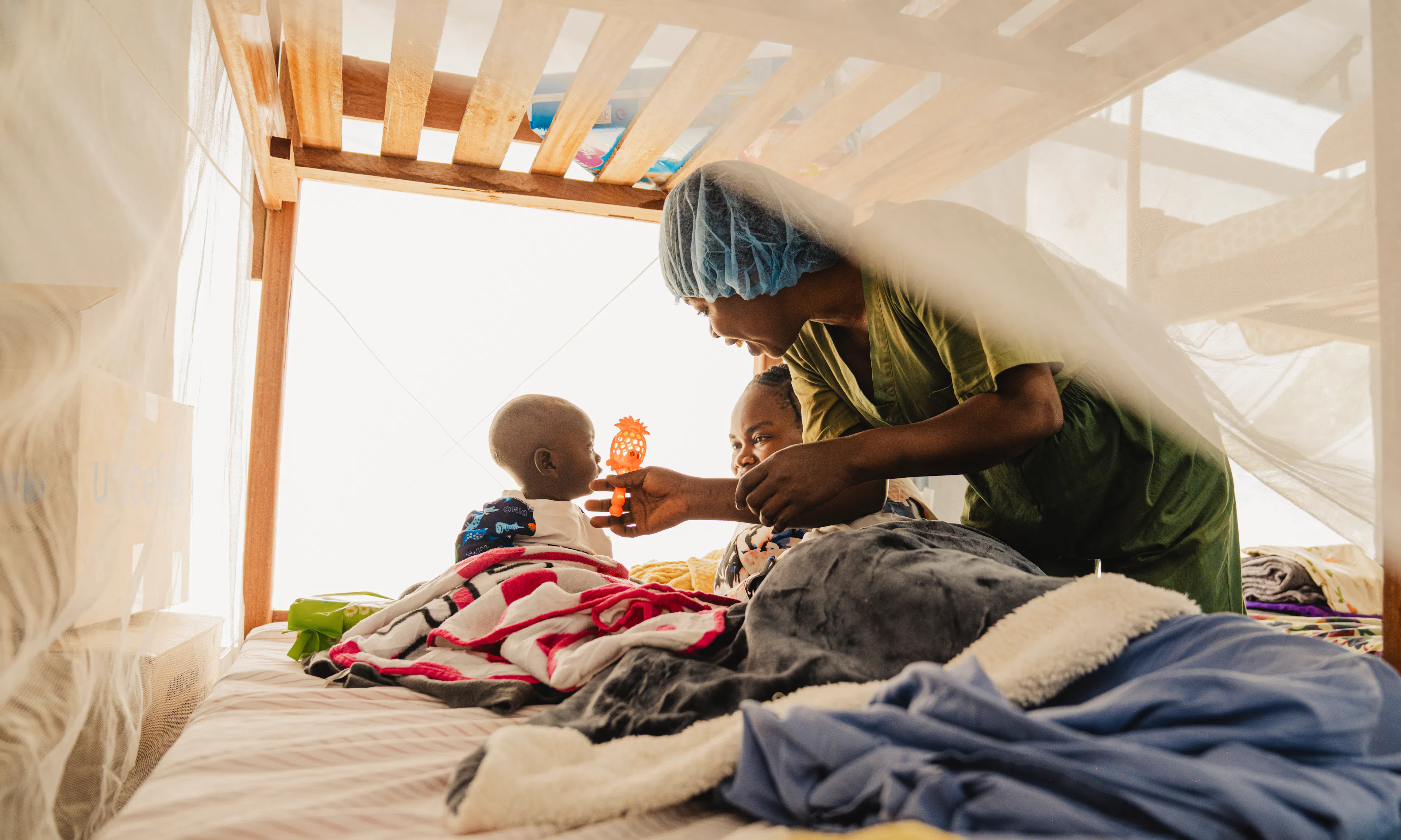Wivine is with a child at the nursery for children whose parents are hospitalized at the Ebola Treatment Center in Bunia, Ituri province.