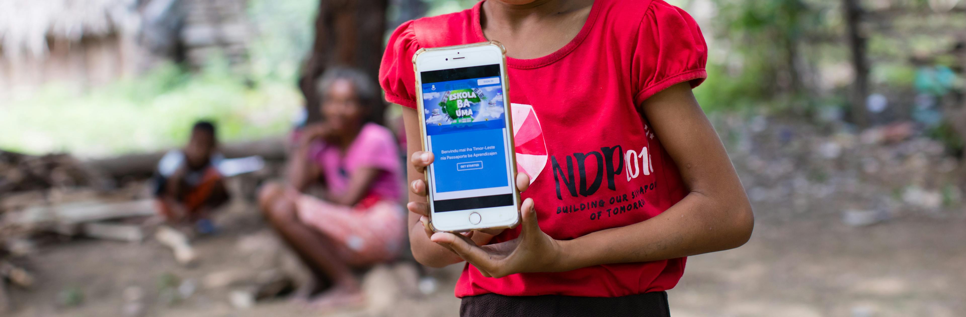 On 14 April 2020, a girl shows off the online platform on which children and parents in Timor-Leste can access a range of audio-visual material to help students continue learning during ongoing school closures.