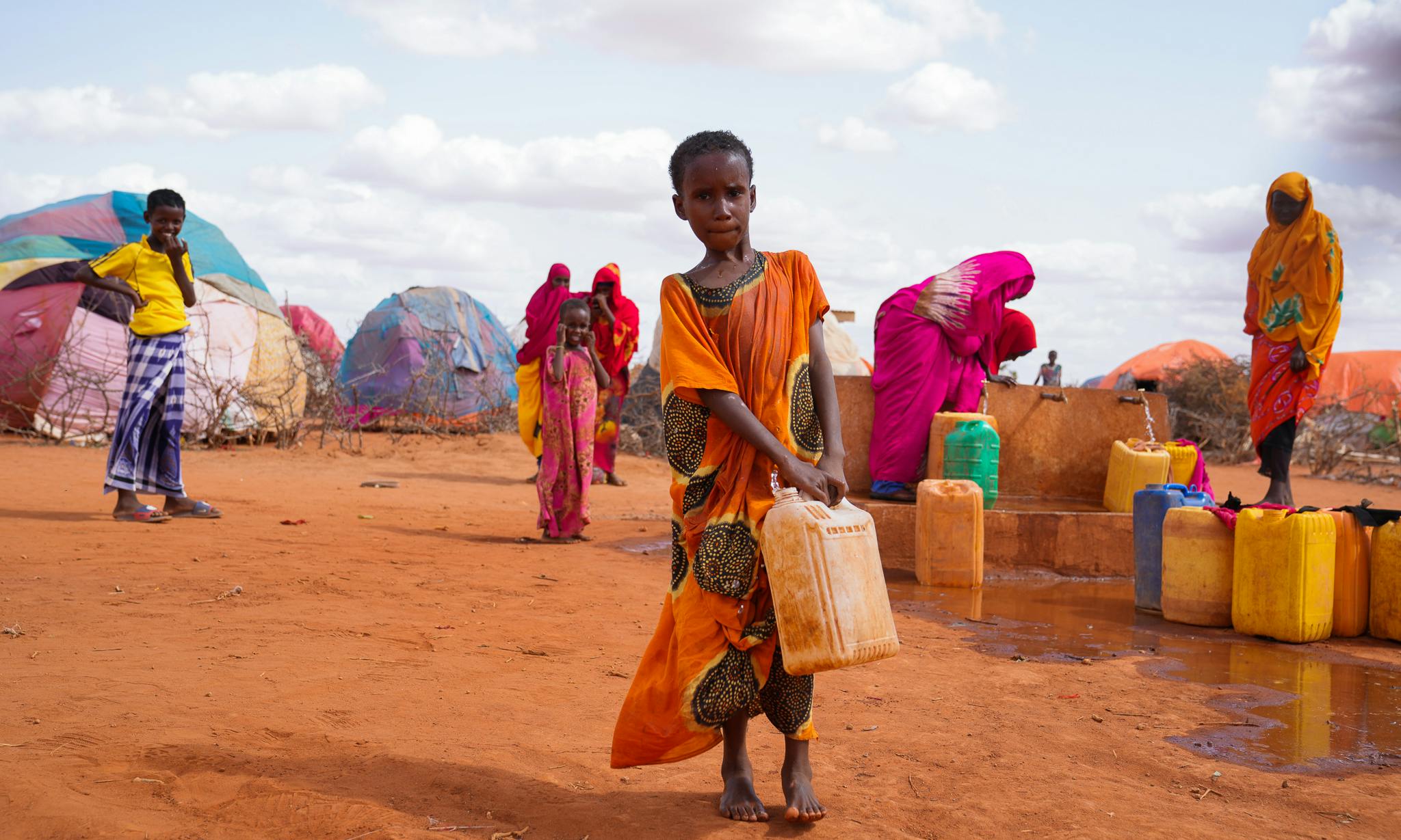 A young girl carrying a container of clean water made possible by a tap water system installed by UNICEF.