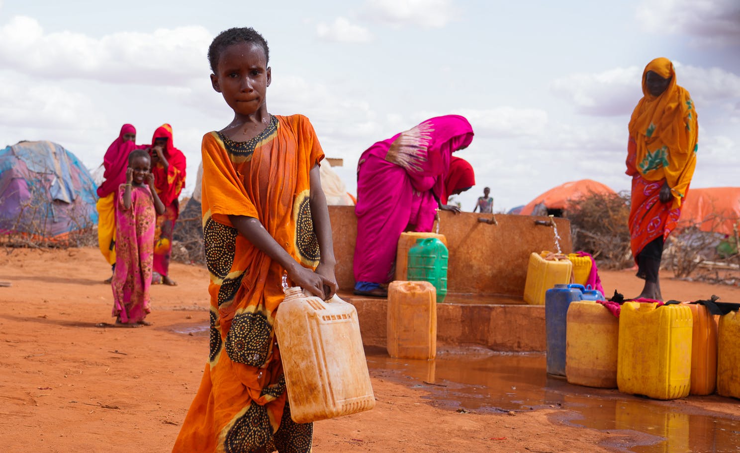 10-year-old Hibo carries water in a jerrycan to her temporary house at Kaharey IDP camp in Dollow, Somalia.