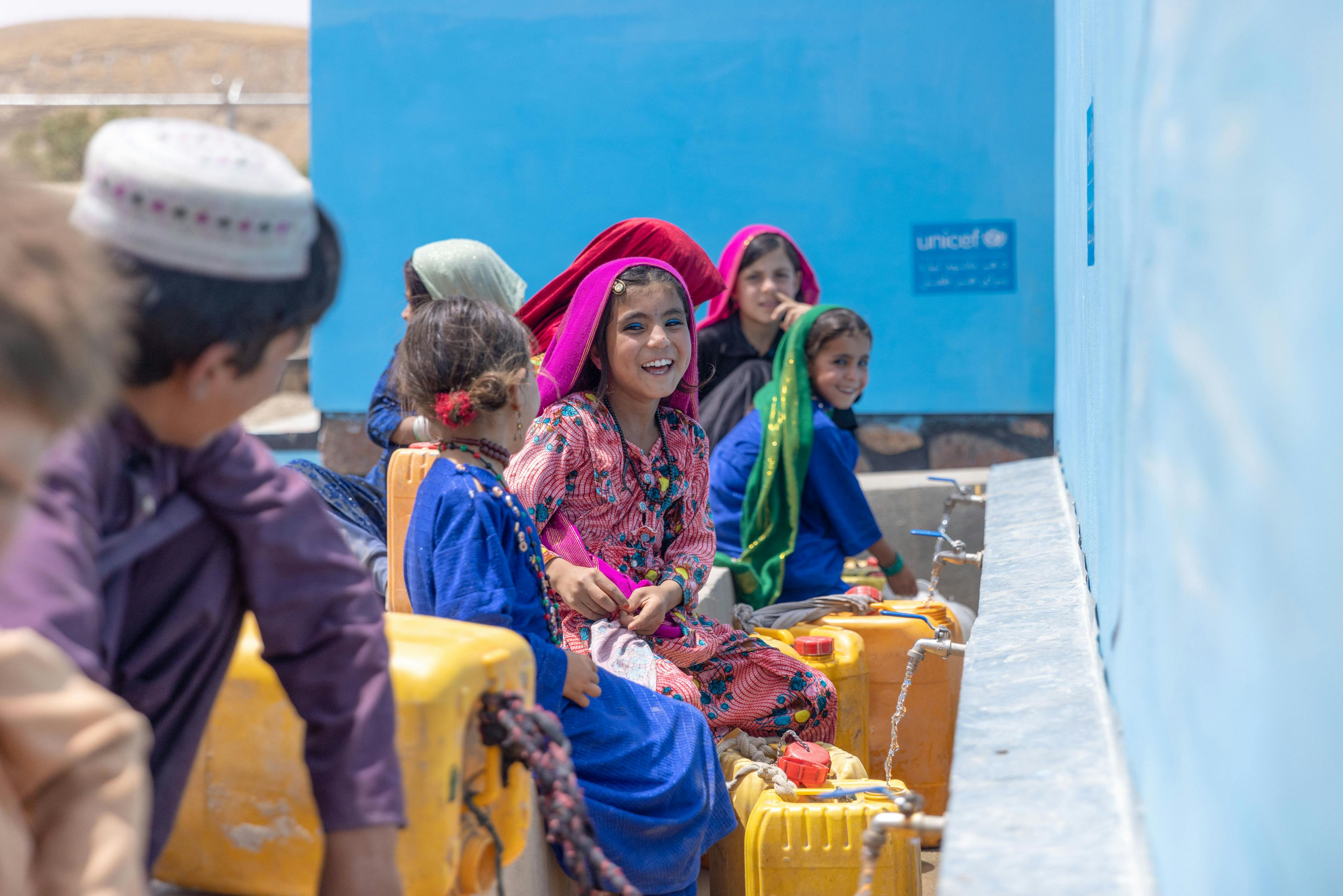 Children collect water from a UNICEF supported tap, located in the heart of their village in Badghis Province, Afghanistan.