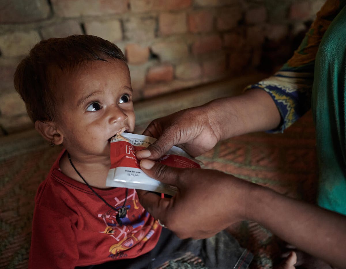 After washing his face and hands, Reshma feeds her son Azaan Ali therapeutic food that she received from UNICEF's mobile clinic at Ismail Bhand village, Pakistan. Little Azaan has been diagnosed with Severe Acute Malnutrition (SAM) by a doctor at the clinic.