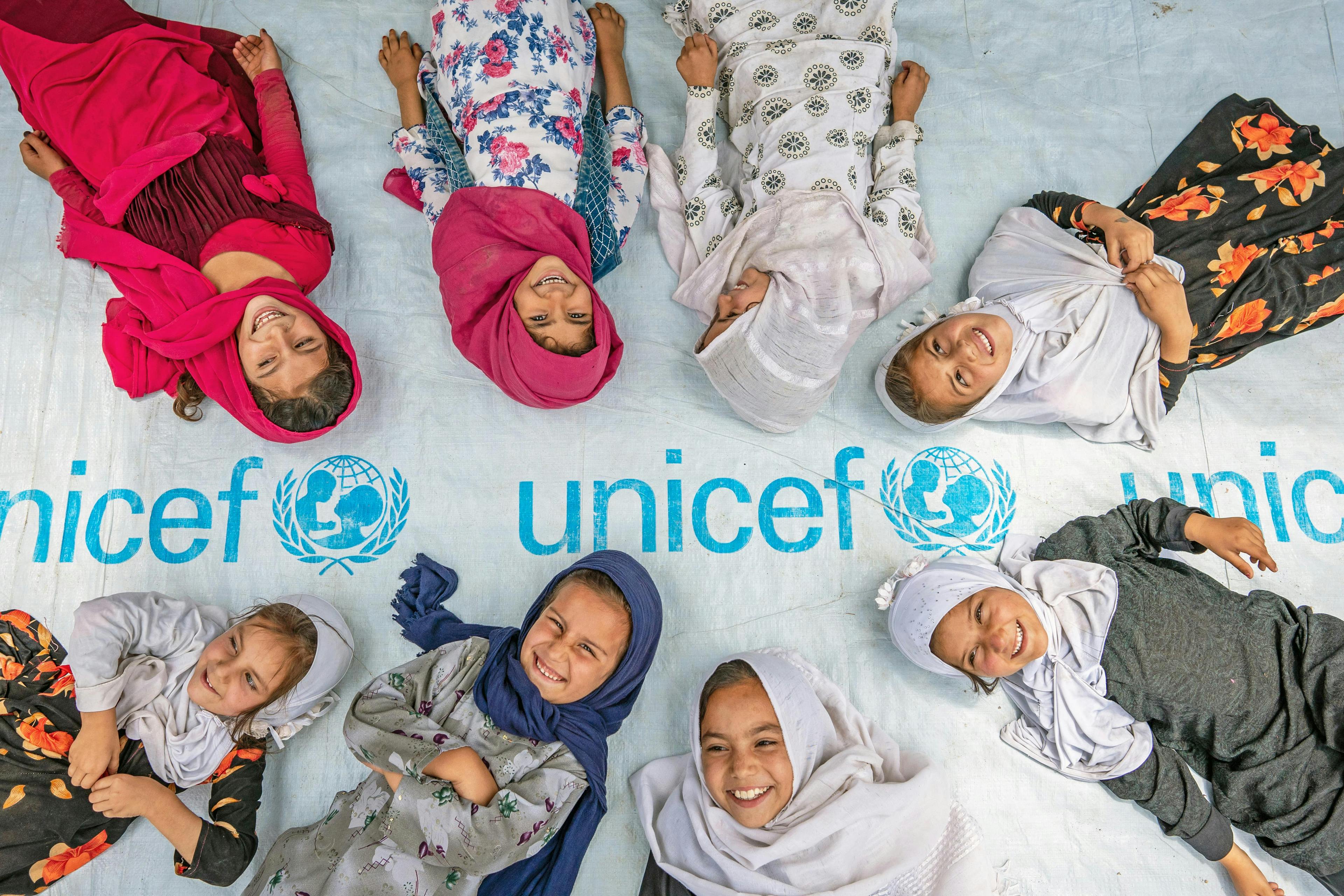 Girls pose at the entrance to a UNICEF-supported community-based education centre in Hijrat Mina in Bagrami District, Kabul Province, Afghanistan.