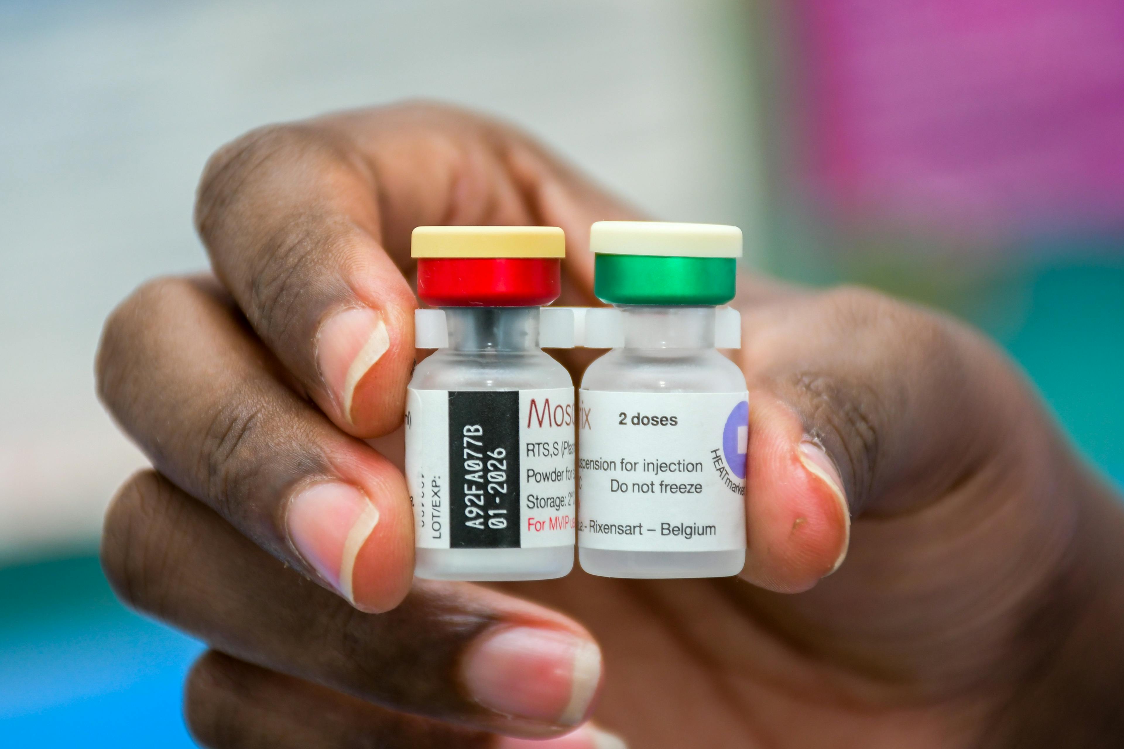 On 24 November 2023 in Kenya, health worker Sharon Mito holds vials of malaria vaccine at Kisumu Airport Health Centre, which will be administered to children.