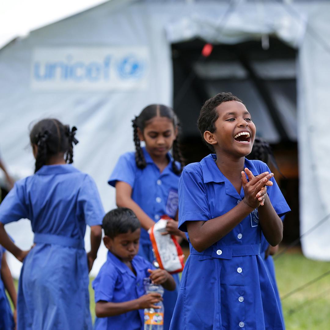 Fiona Dawn, 12 of Dreketi Primary School, smiles while standing in front of the newly set up UNICEF-supplied temporary school classroom.