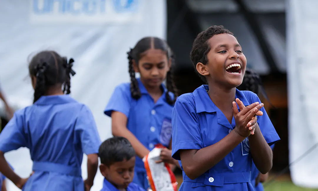 Fiona Dawn, 12 of Dreketi Primary School, smiles while standing in front of the newly set up UNICEF-supplied temporary school classroom.
