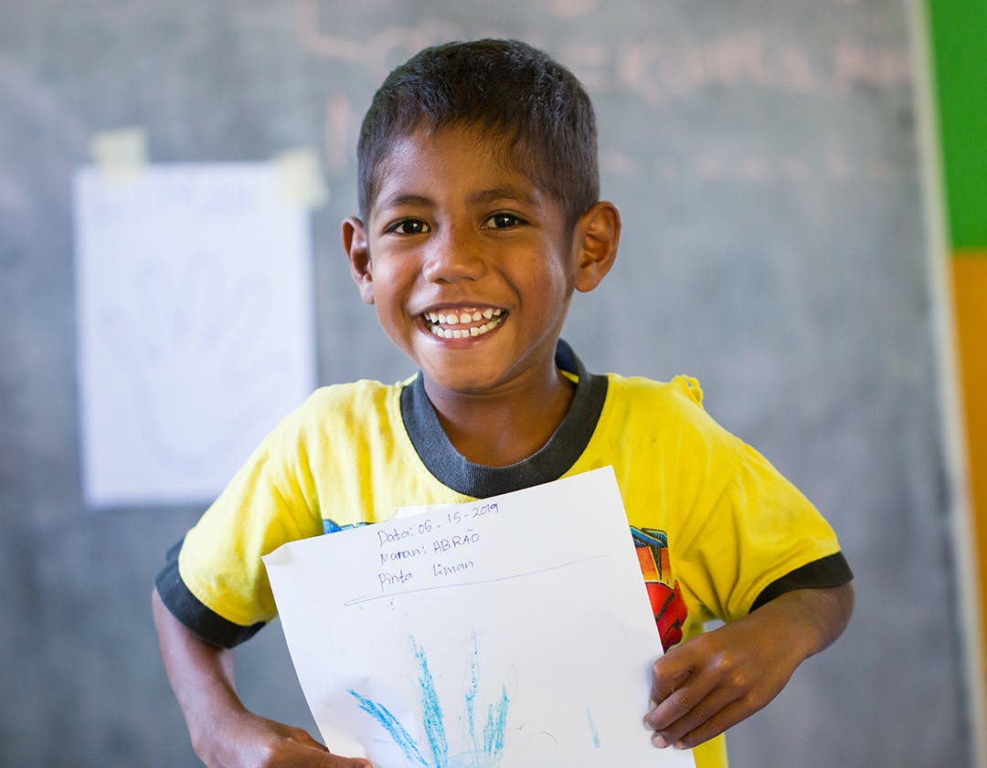 Abrão Gusmão showing the result of his painting. Community preschool.