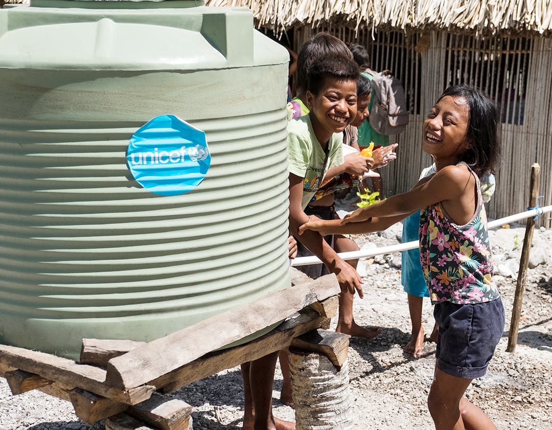 Students of Nikuao Primary School washing their hands from tippy-taps installed outside of their classrooms. Abaiang Atoll, Kiribati.