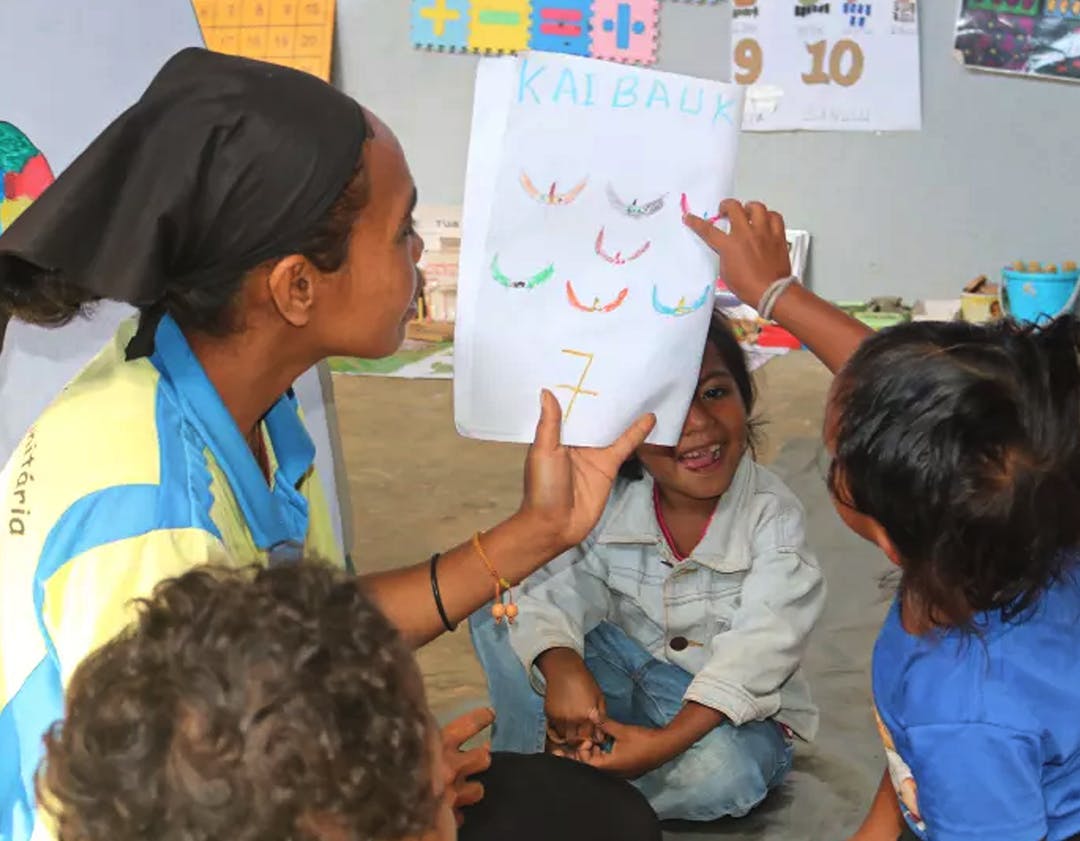 Facilitator Almeria dos Santos is using some of the learning materials to teach the children at Titibuti community-based preschool.