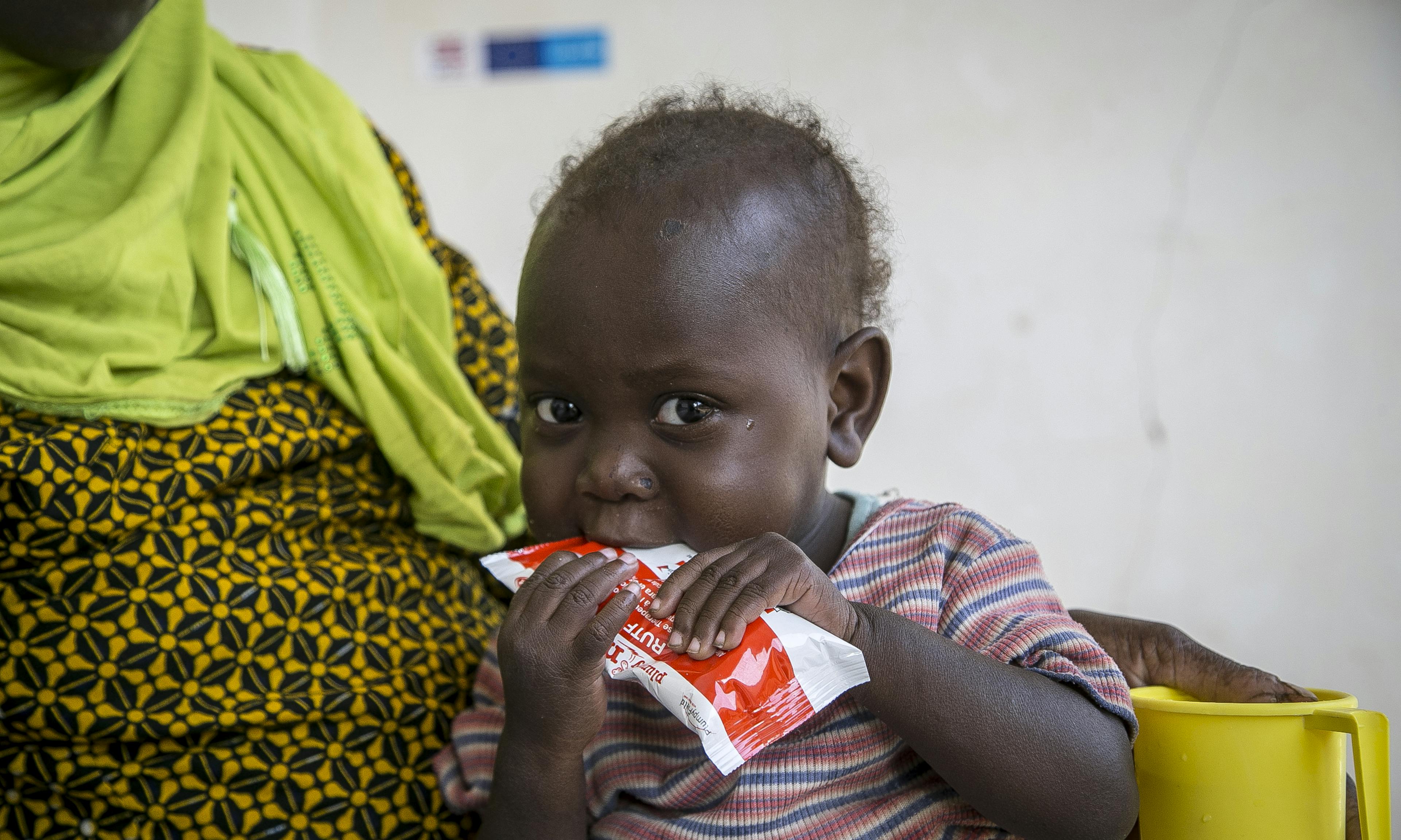 Oumou Bah, 2, eating ready-to-use therapeutic food 