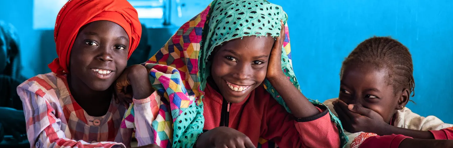A group of girls at school smile at the camera