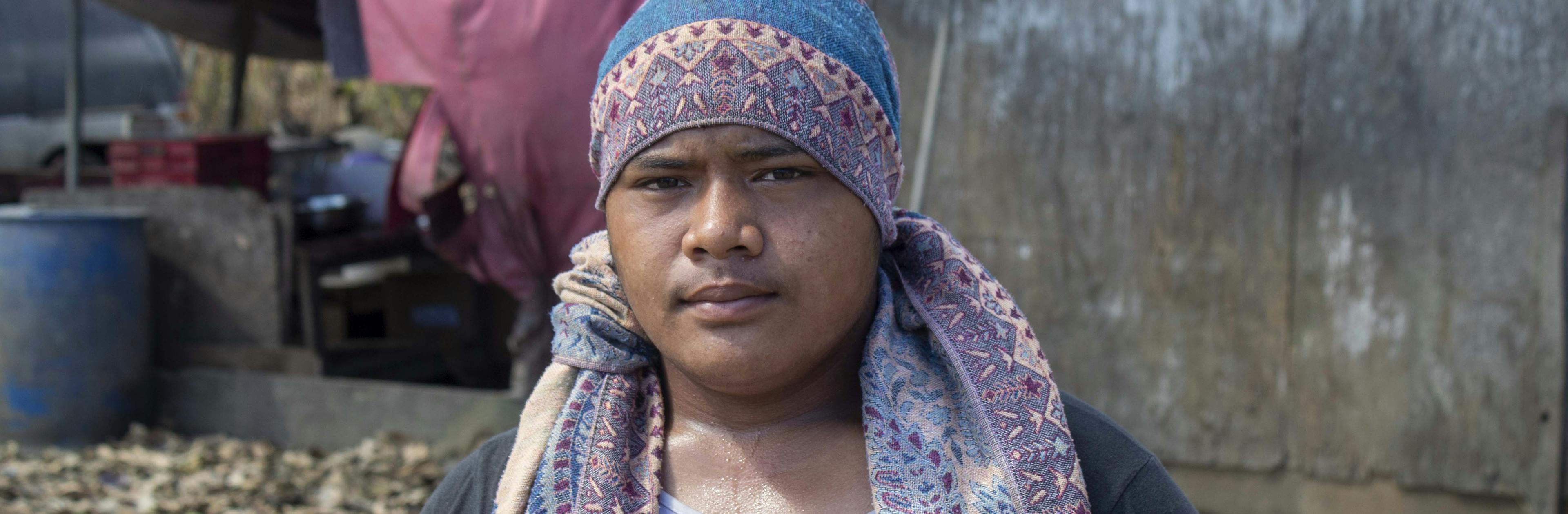 On 22 January 2022, Semisi Fataua, 15 years old, stands in front of his home in Kanokupolu village on Tongatapu, Tonga’s main island, with damage caused by the Hunga Tonga-Hunga Ha’apai underwater volcano eruption and tsunami. 