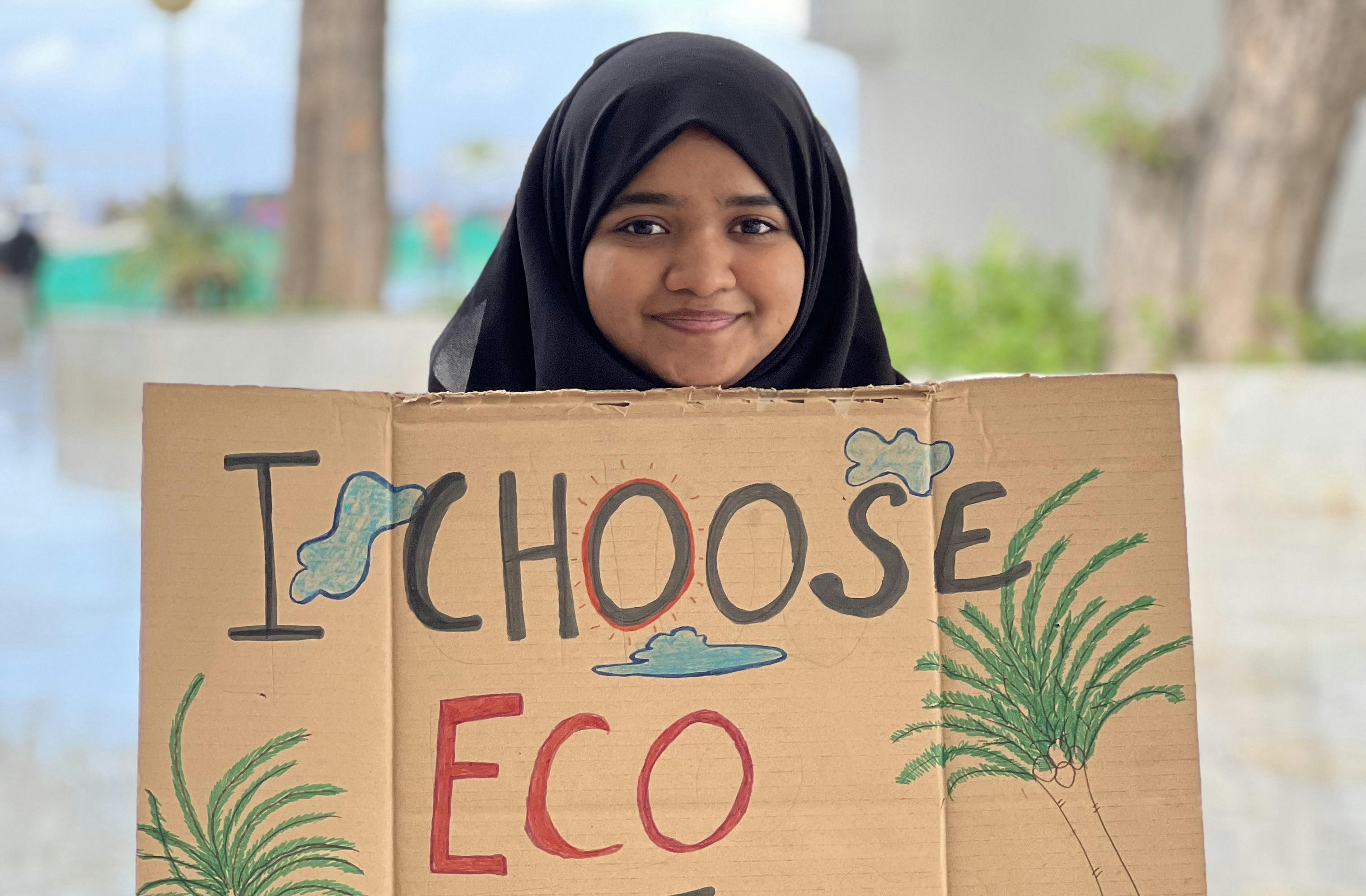 child holding sign that says 'I choose eco"