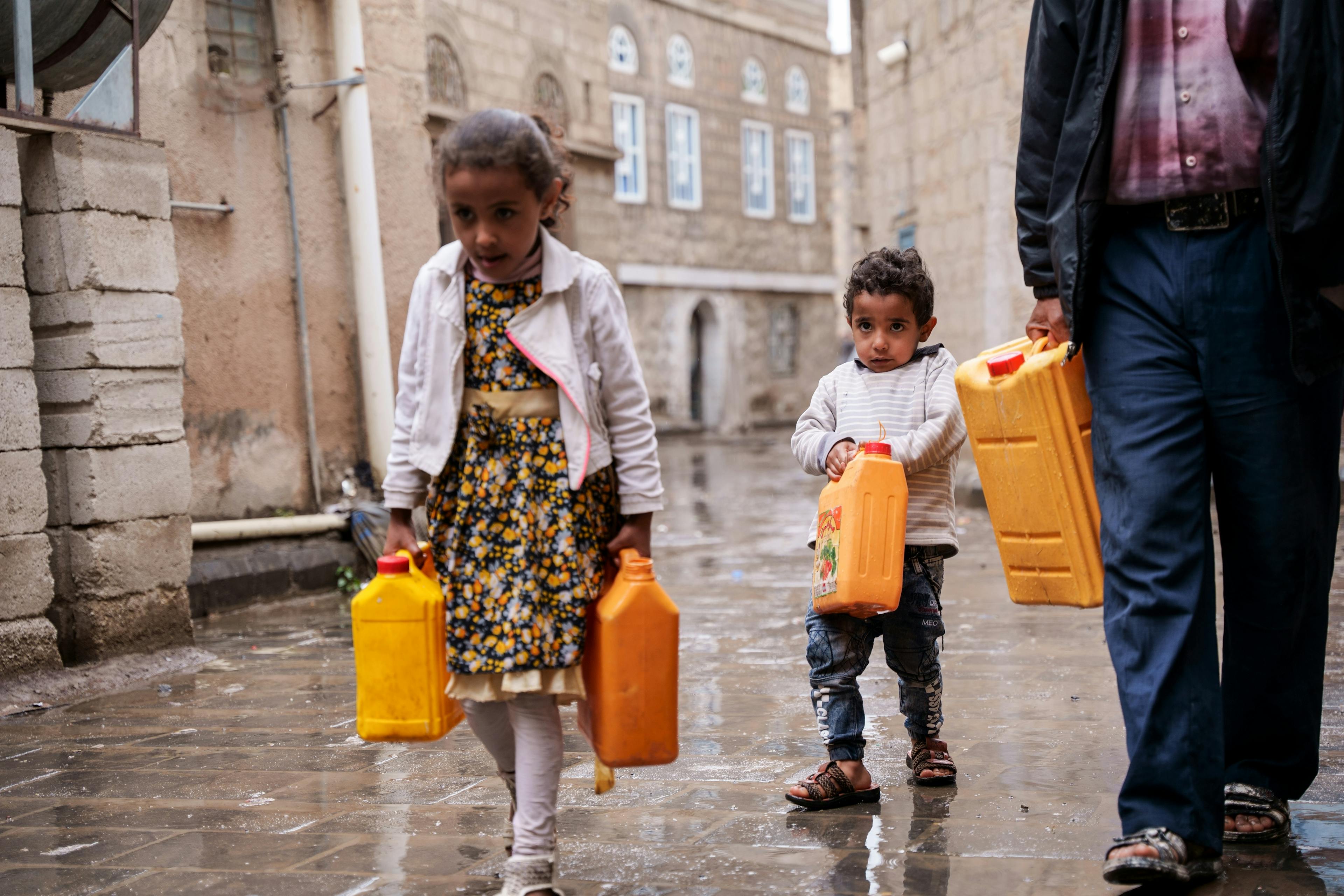 Nabil takes his children, Mayar, and Mohammed, to fetch water from a nearby charity tank in Dhamar Governorate, Yemen