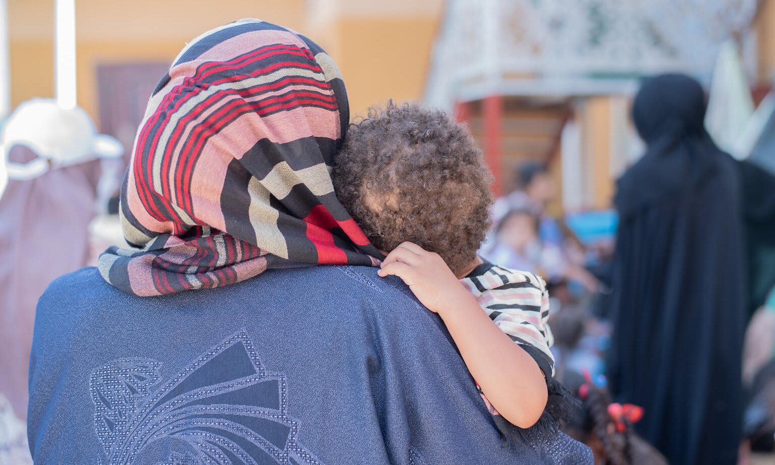 On 9 May 2023, amidst an eventful open day of entertainment at the Maritime Ports Authority Club in Port Sudan, which currently serves as a temporary shelter for internally displaced persons, a nurturing mother tenderly cradles her small child.