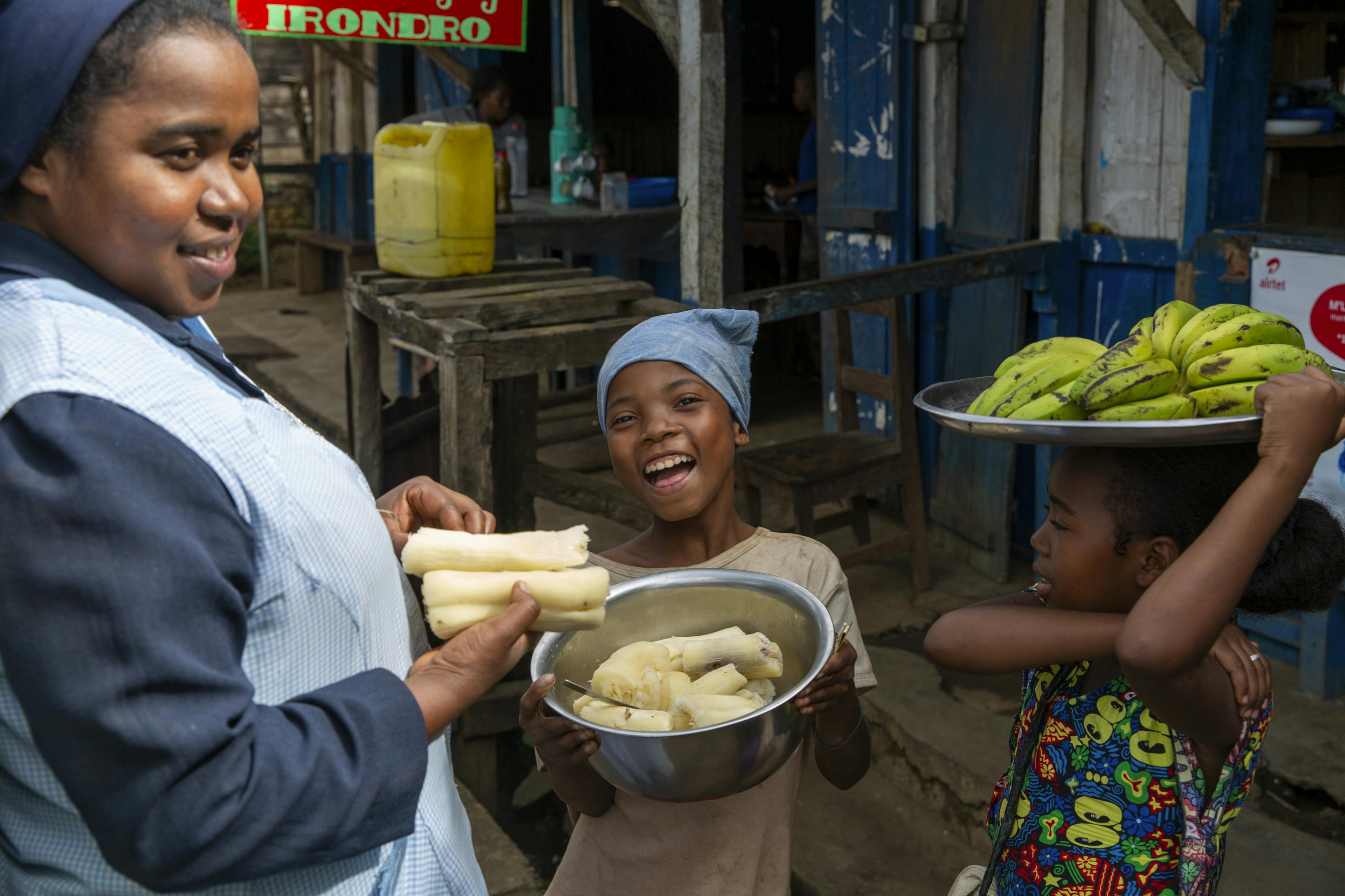 A young girl smiles as she holds some fresh produce