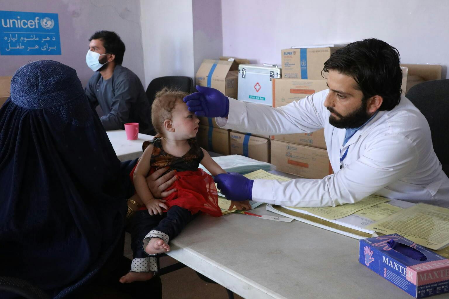 Baby Rana (1) gets checked by a nurse while visiting a mobile health and nutrition team in Deh Sabz, Afghanistan.