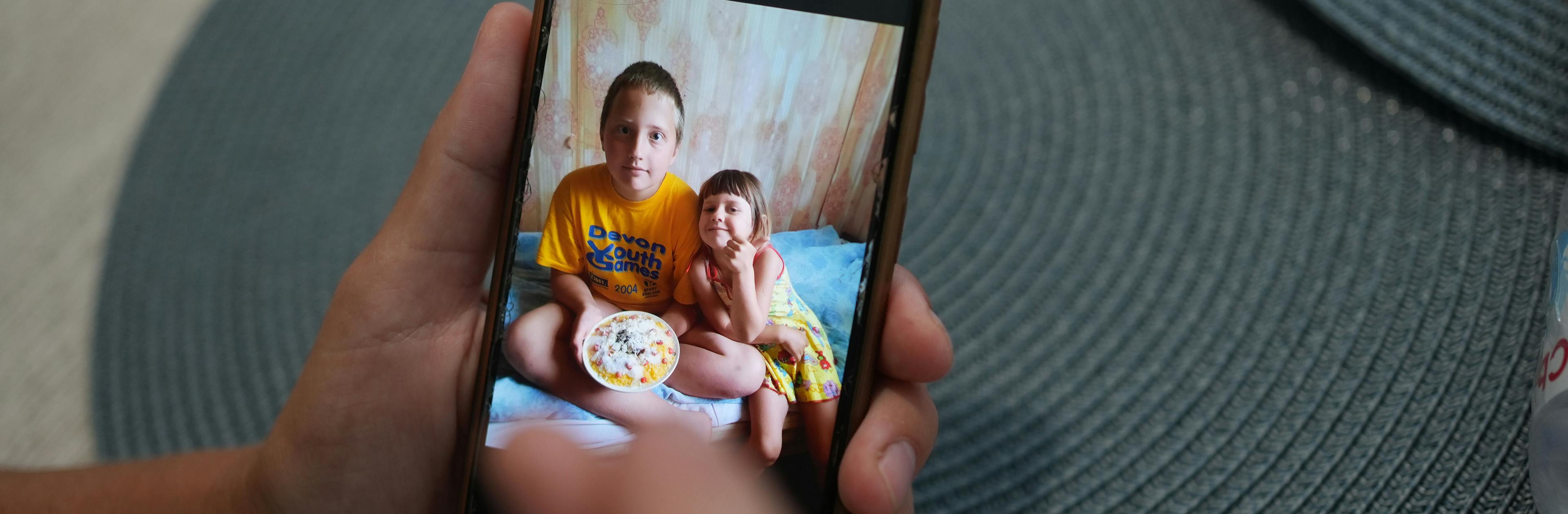 June 6, 2023, Chaika, Khersonska district, Ukraine. Kateryna, who was evacuated with her family from her home because of flooding, is showing a picture of her kids on her phone screen. Maksym is 12 and Masha is 4.