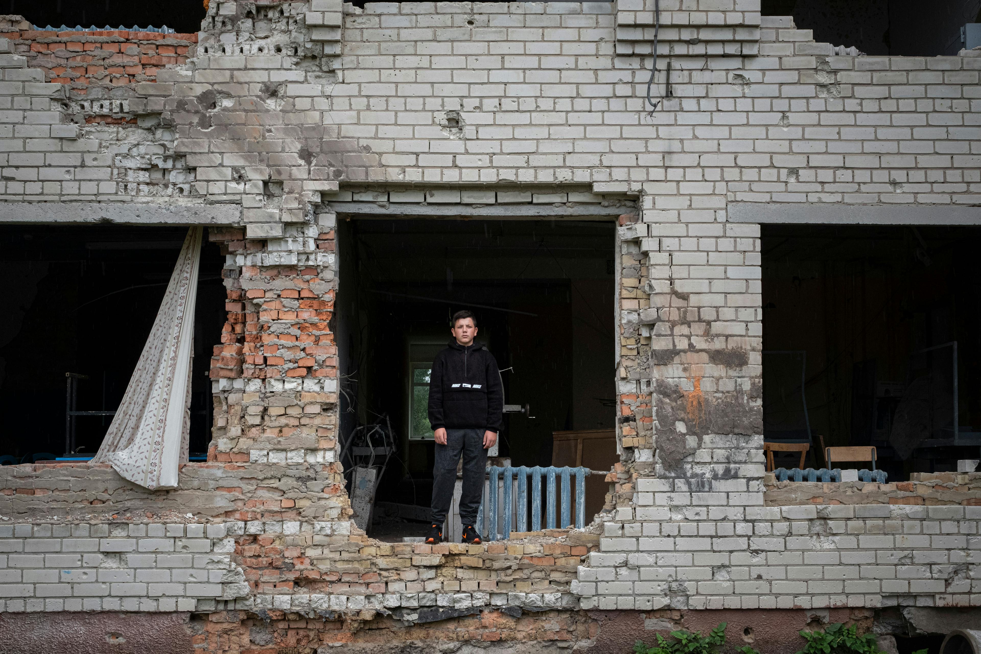 On 13 August 2022, Nazar , 13, poses in his severely damaged school in the village of Olyzarivka, Ukraine.