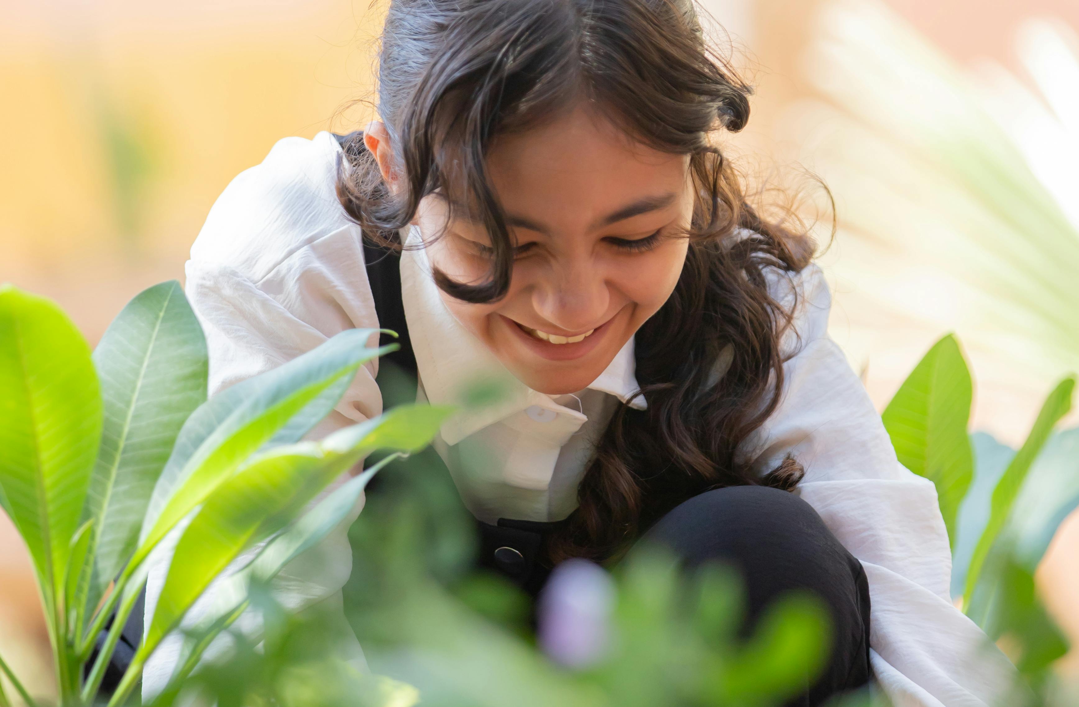 UNICEF summer camp - young girl smiling while attending to garden 