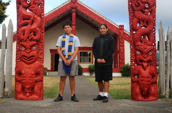 Maori students standing outside wharenui